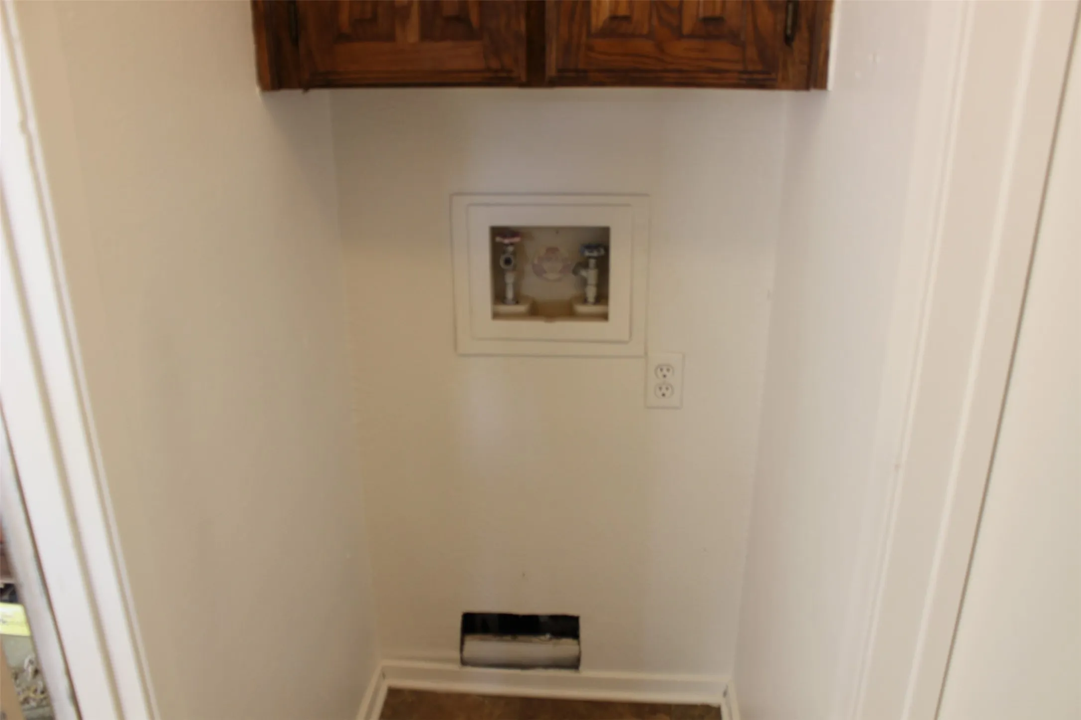 Laundry area featuring wood-finish flooring, overhead cabinetry, and appliance hookups