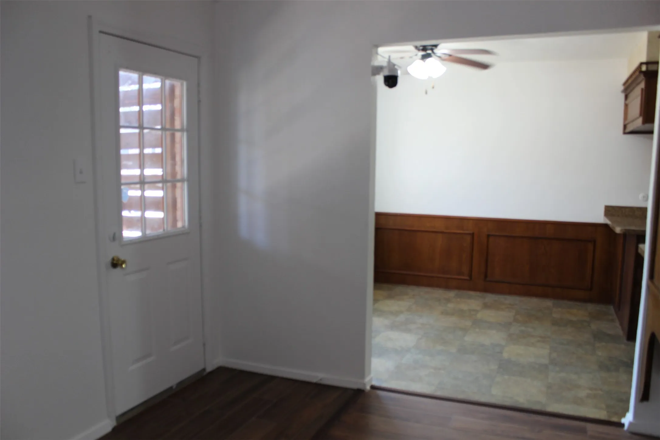 Wood-finish flooring leading to an interior door with glass panes