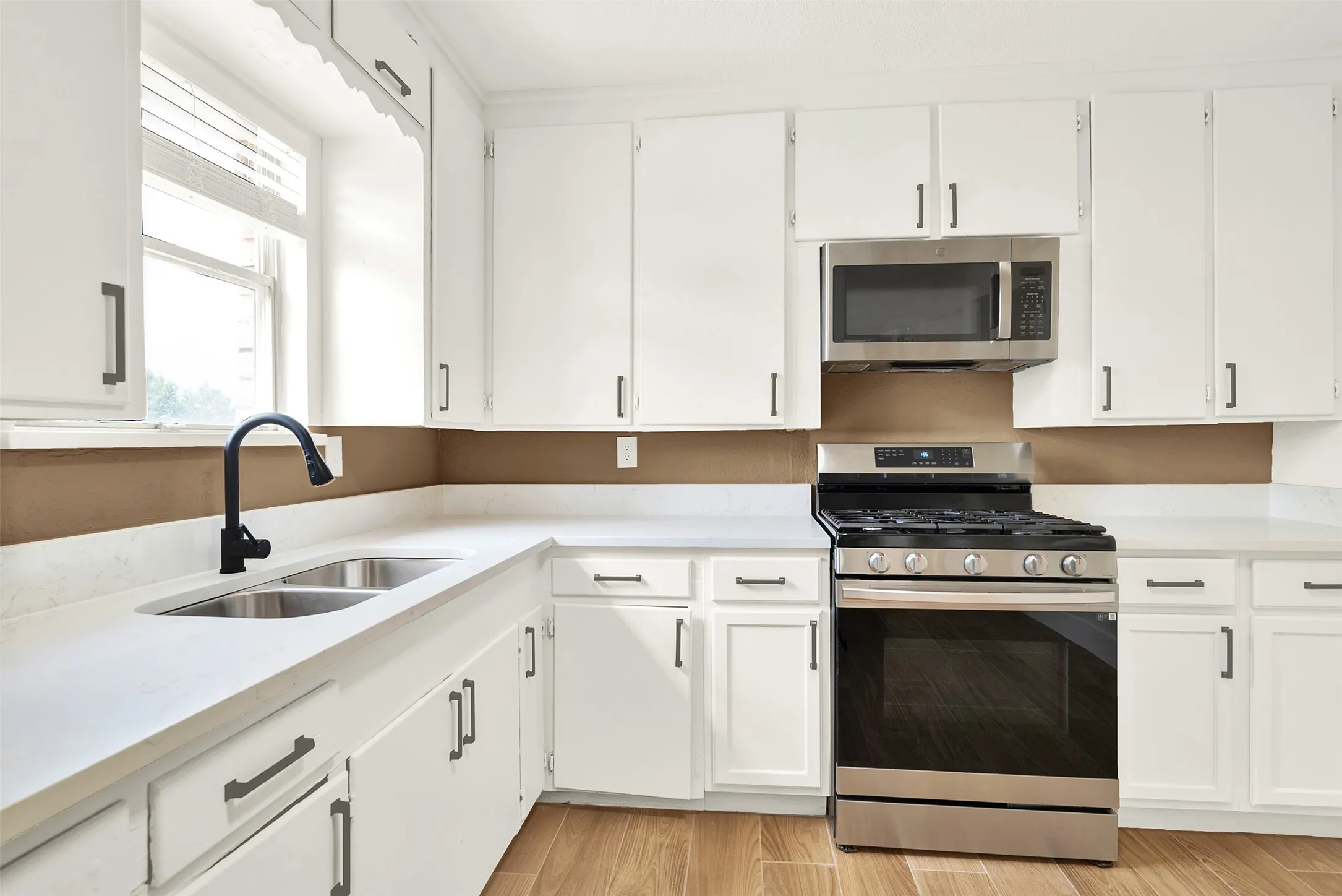 Kitchen featuring light hardwood / wood-style flooring, stainless steel appliances, sink, and white cabinetry