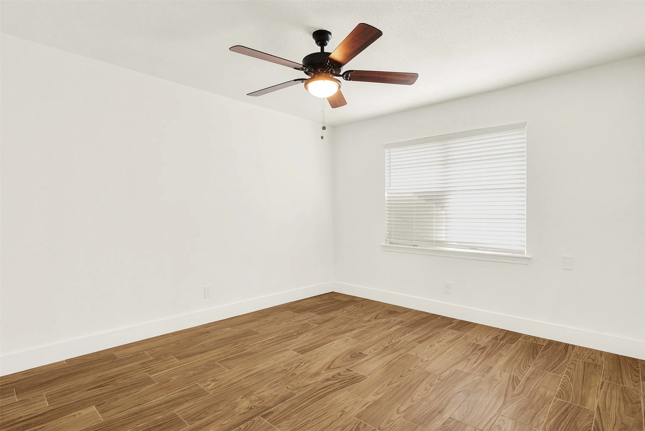 Unfurnished room with light hardwood / wood-style flooring and ceiling fan