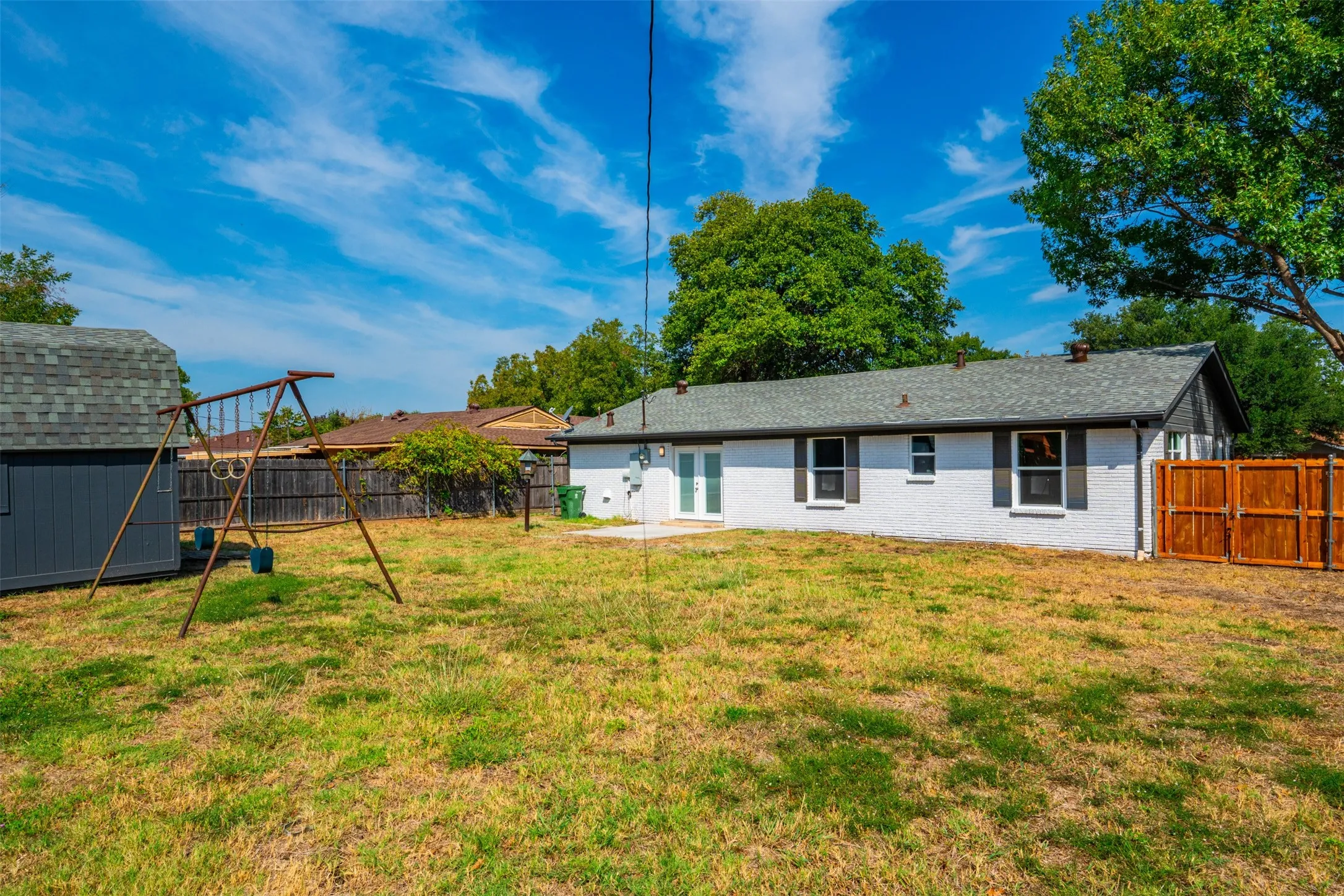 Spacious backyard featuring a storage shed, a privacy fence, and a concrete patio