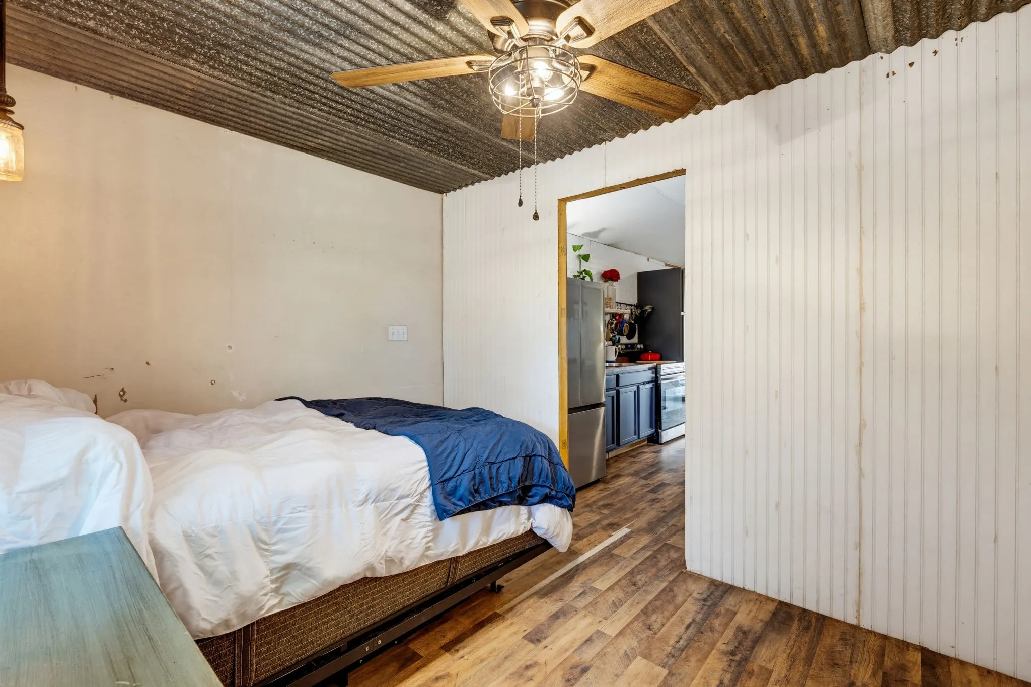 Corrugated metal ceiling with a wood-finish ceiling fan and attached lighting