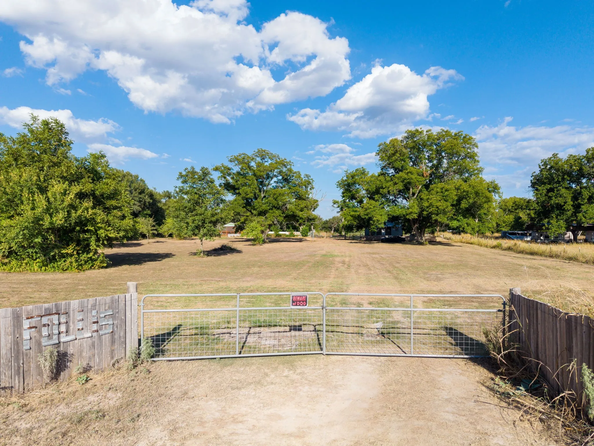Expansive lot with mature trees and a metal gate entrance