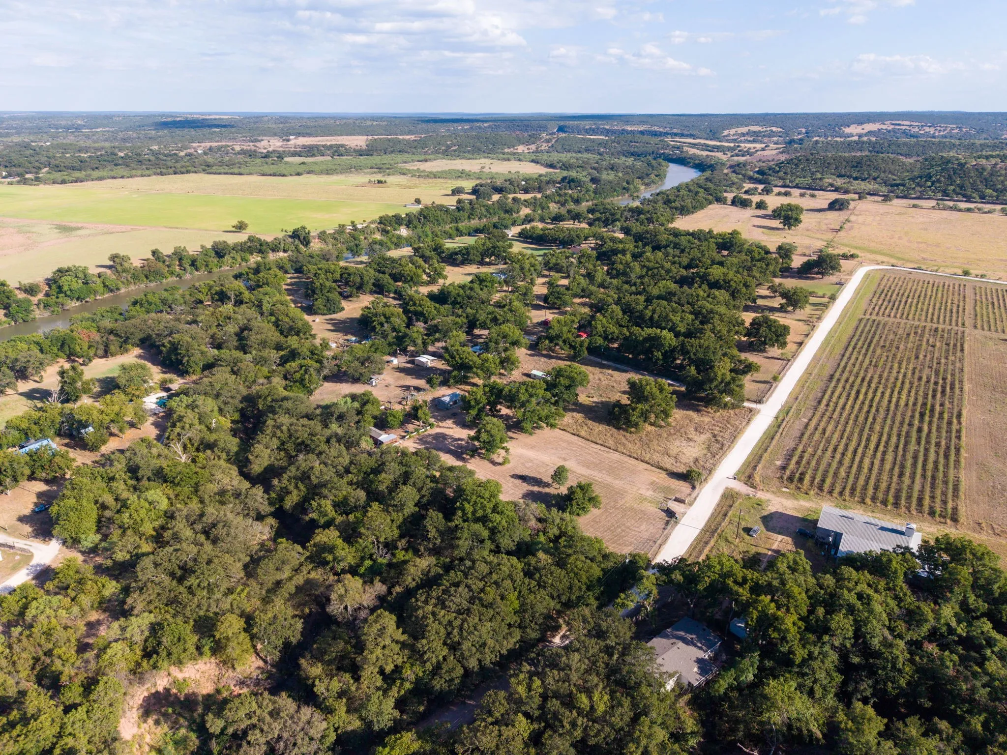 Expansive acreage featuring abundant mature trees, a winding river, and agricultural fields