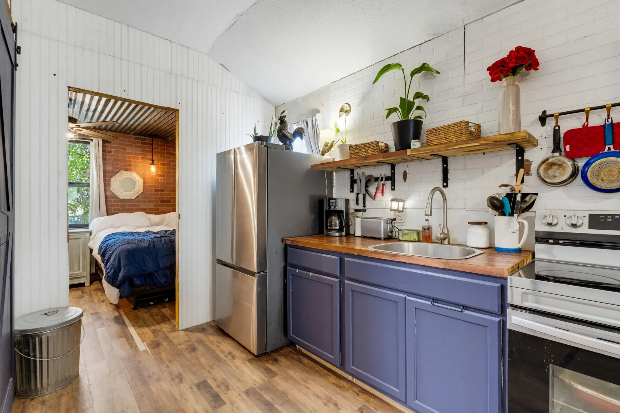 Kitchenette featuring stainless steel appliances, wood-finish countertops, and open shelving
