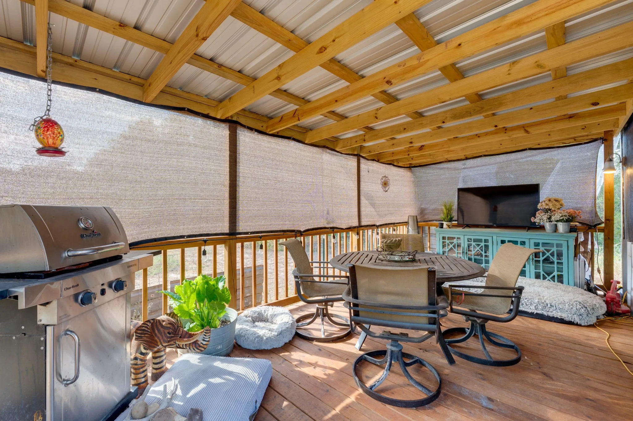 Expansive covered deck featuring a metal roof, exposed wood beams, wood flooring, and perimeter railings