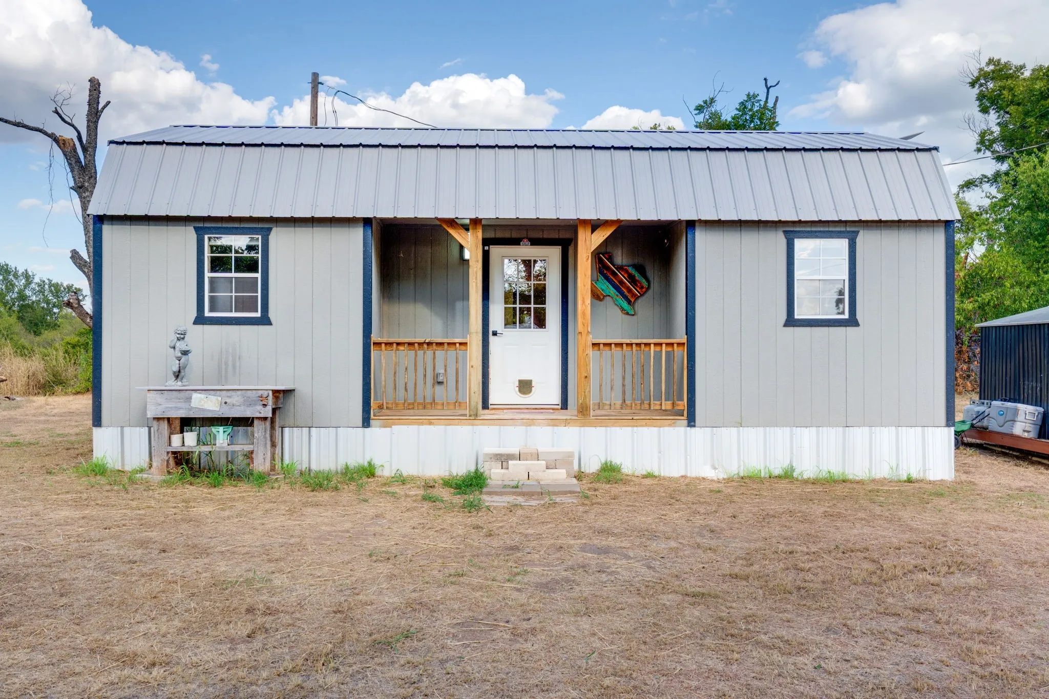 Gray siding exterior with dark trim accents and a metal roof