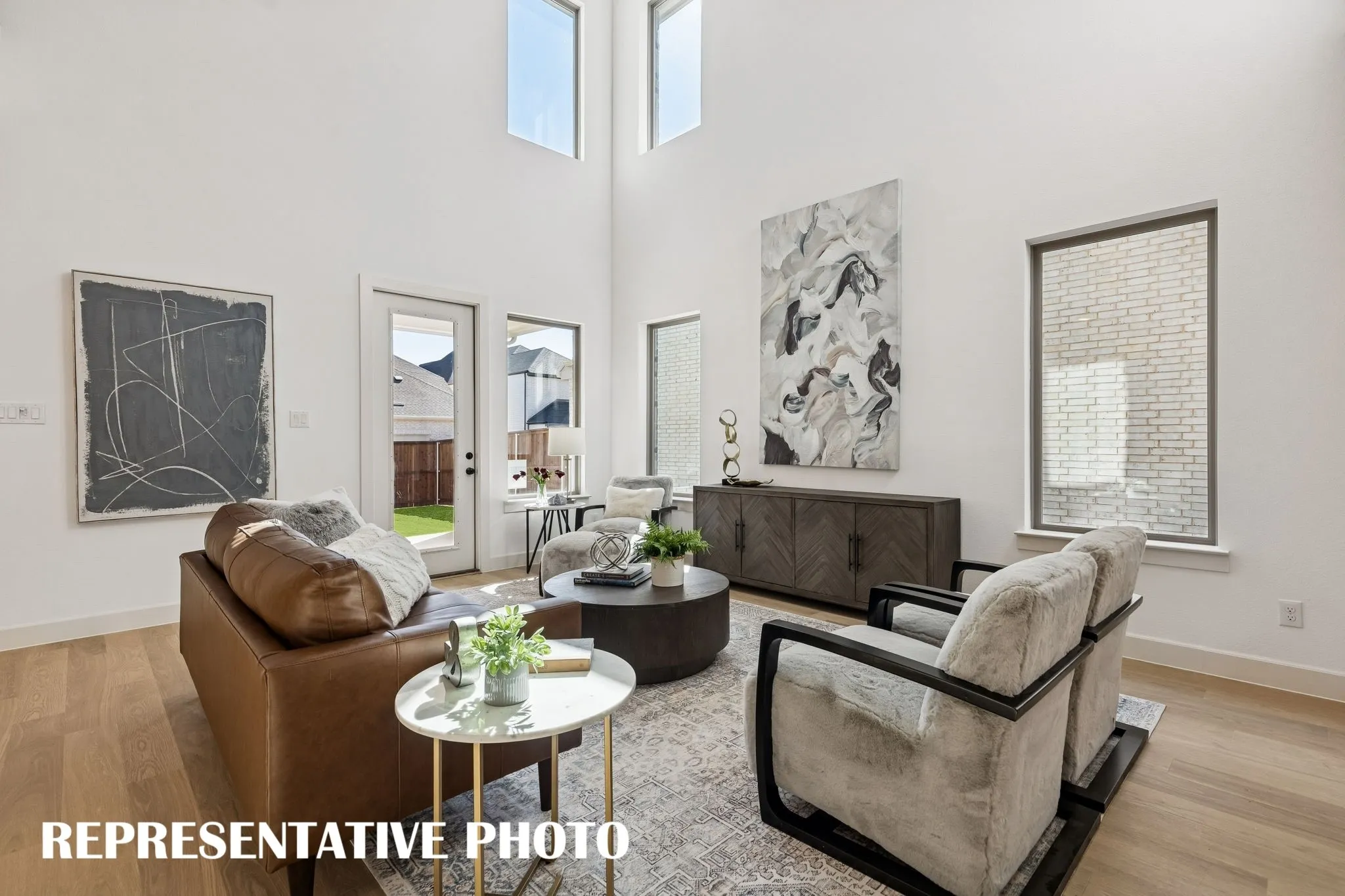 This spacious family room is flooded with natural light from oversized windows on the main and upper levels.REPRESENTATIVE PHOTO