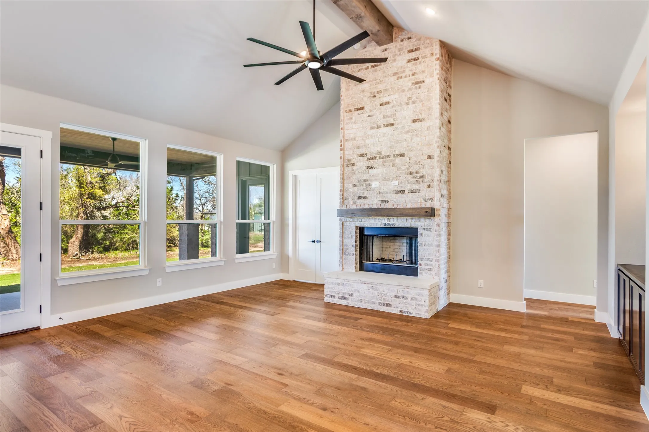 Vaulted ceiling with exposed wood beam, large ceiling fan, and recessed lighting
