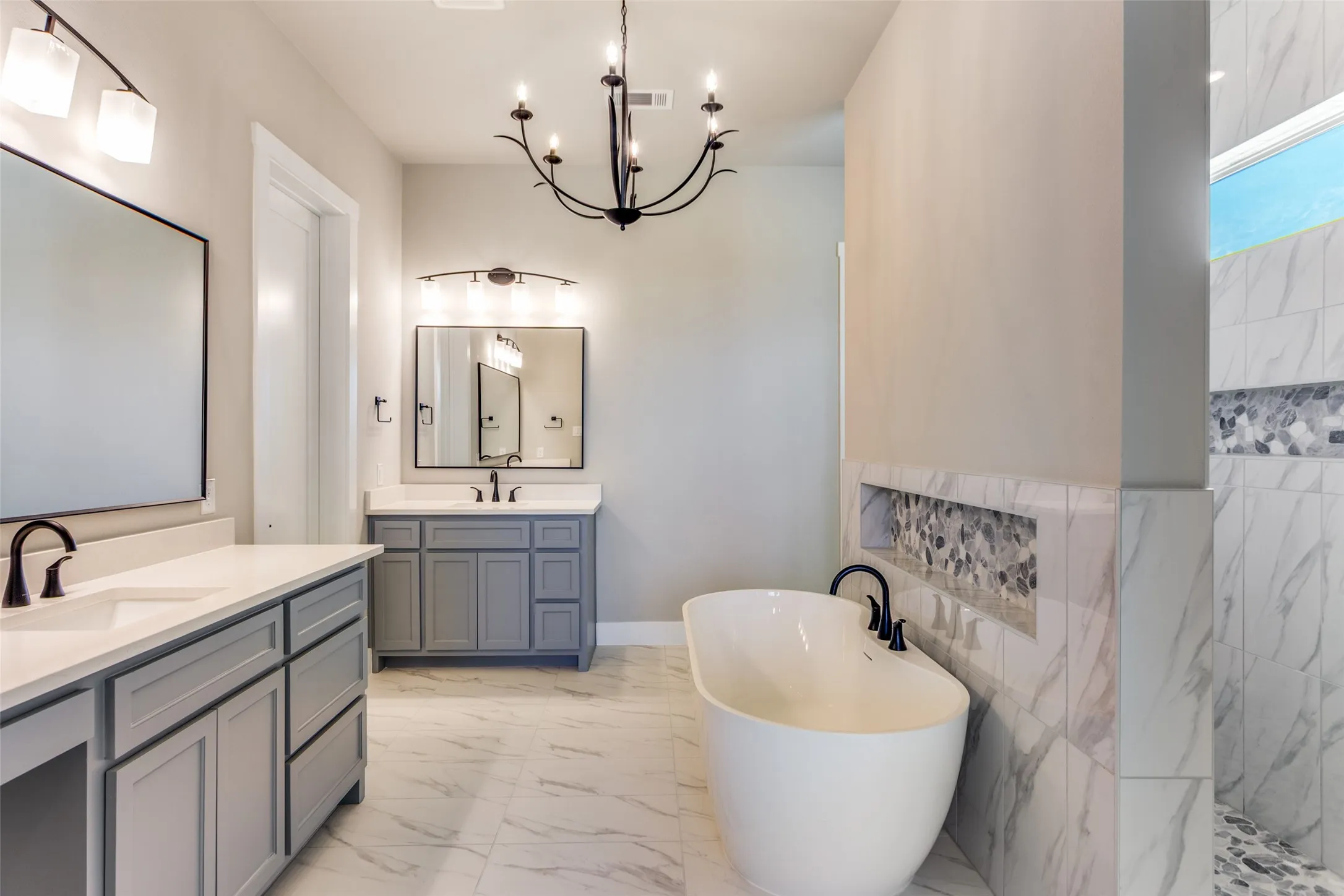 Dual vanities with gray cabinetry and white countertops