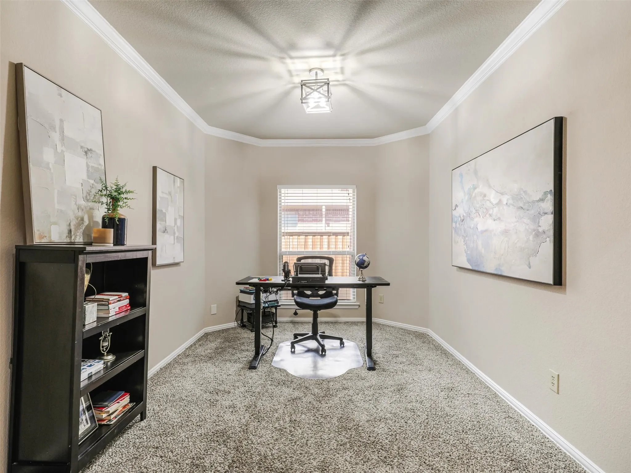 Currently arranged as a home office, this versatile space features crown molding, a decorative ceiling light, and a window for natural light. Space could be used as a formal dining area as well.