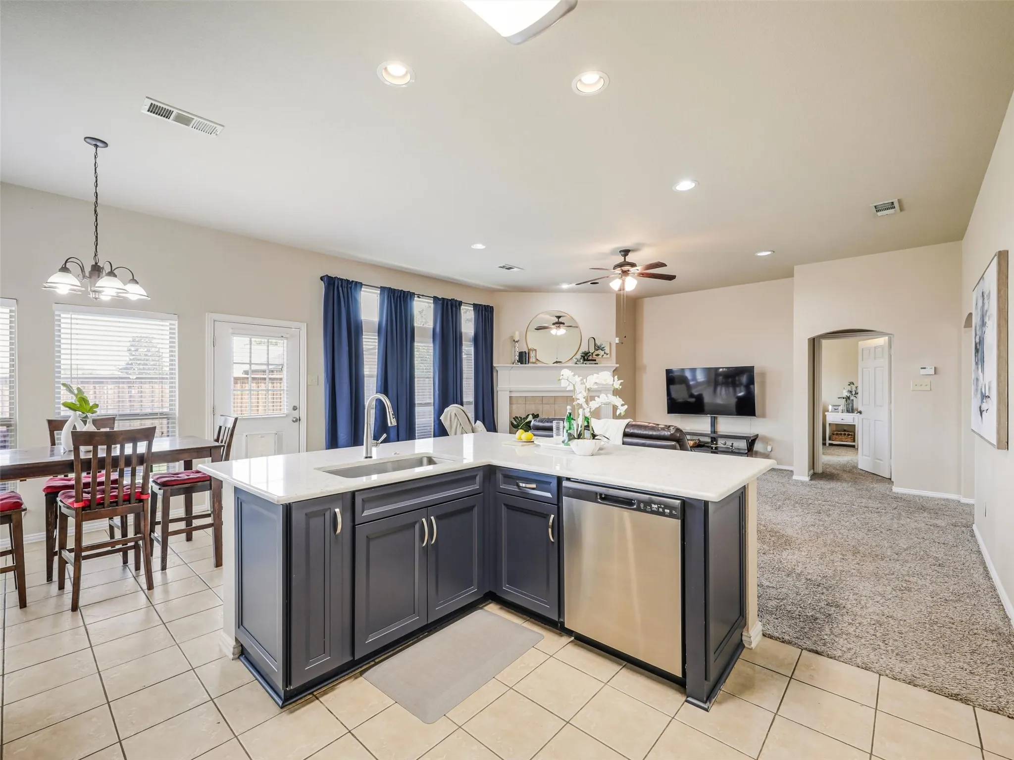 Kitchen peninsula features additional cabinet storage and a stainless steel dishwasher, with an open view of the breakfast nook and living room.
