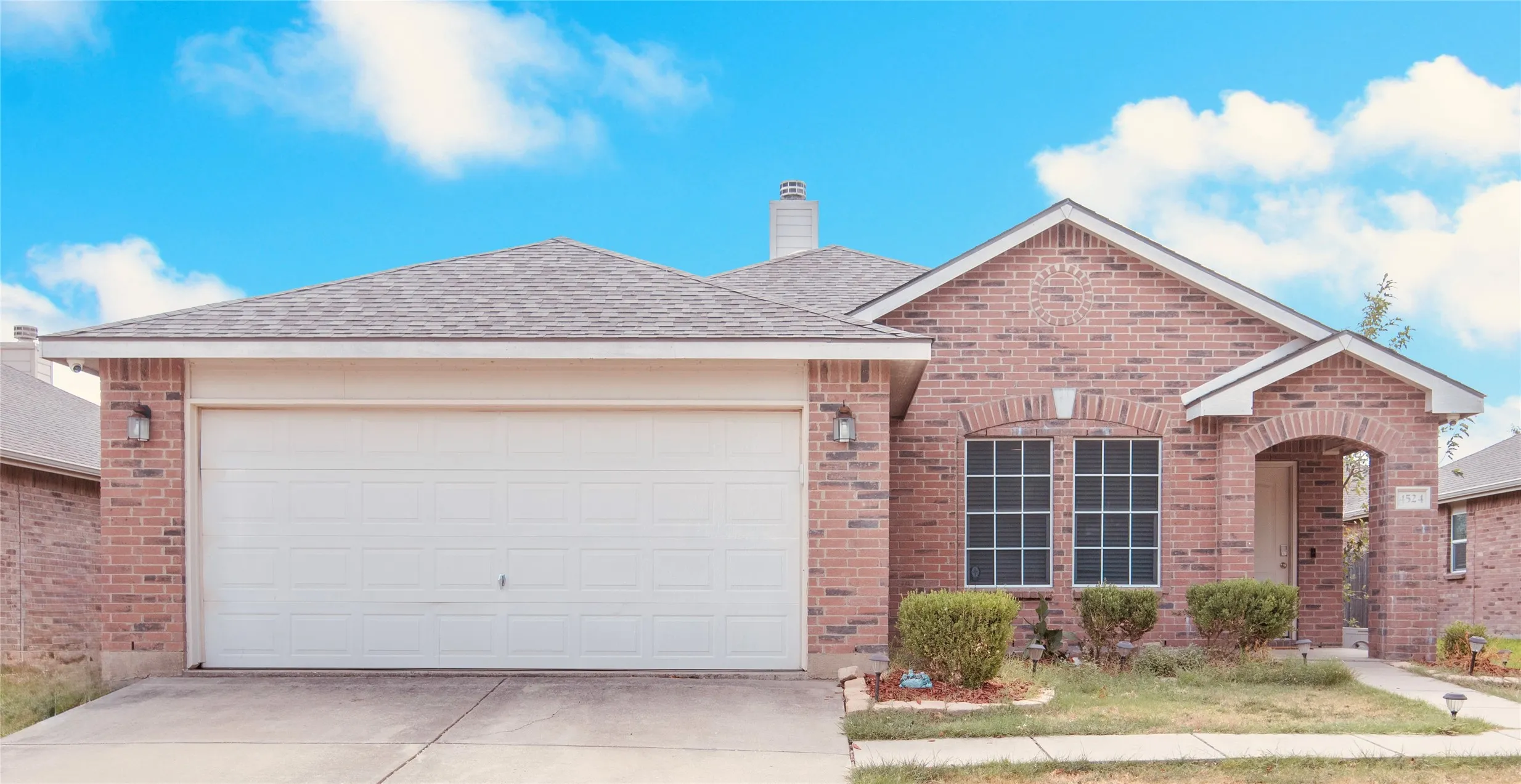 Brick exterior with a gabled roof and attached two-car garage