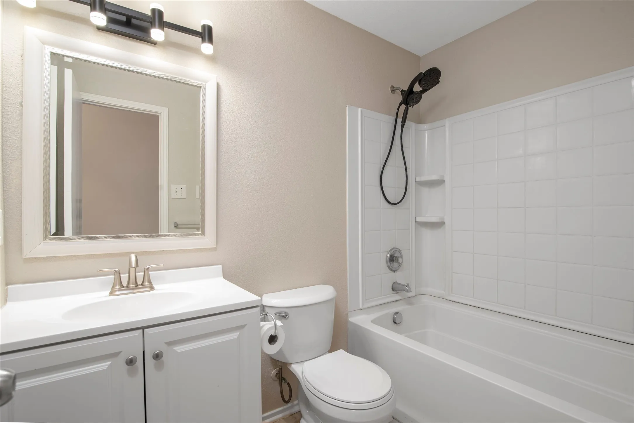 White vanity with dual-door cabinetry, a single basin sink, and brushed nickel faucet
