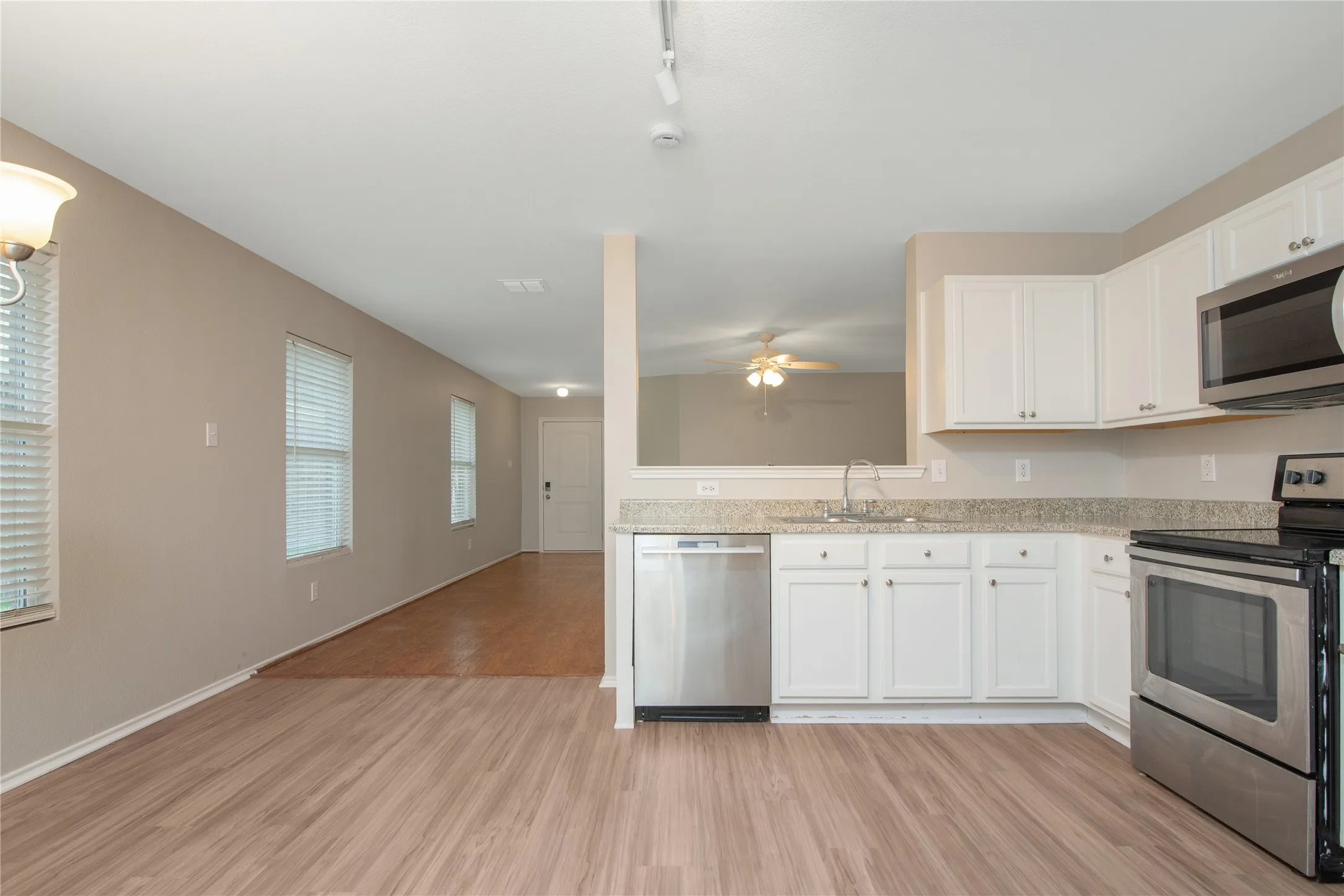 Kitchen featuring white cabinetry, granite-finish countertops, and stainless steel appliances