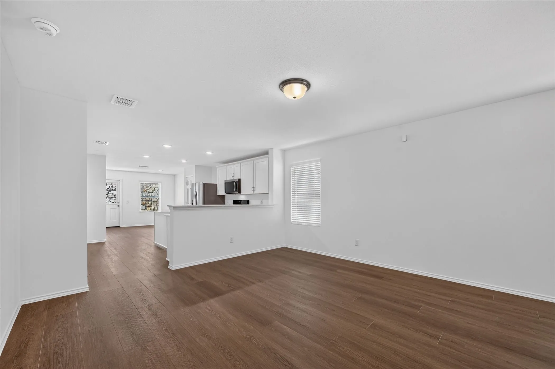 Open concept living space with wood-finish flooring