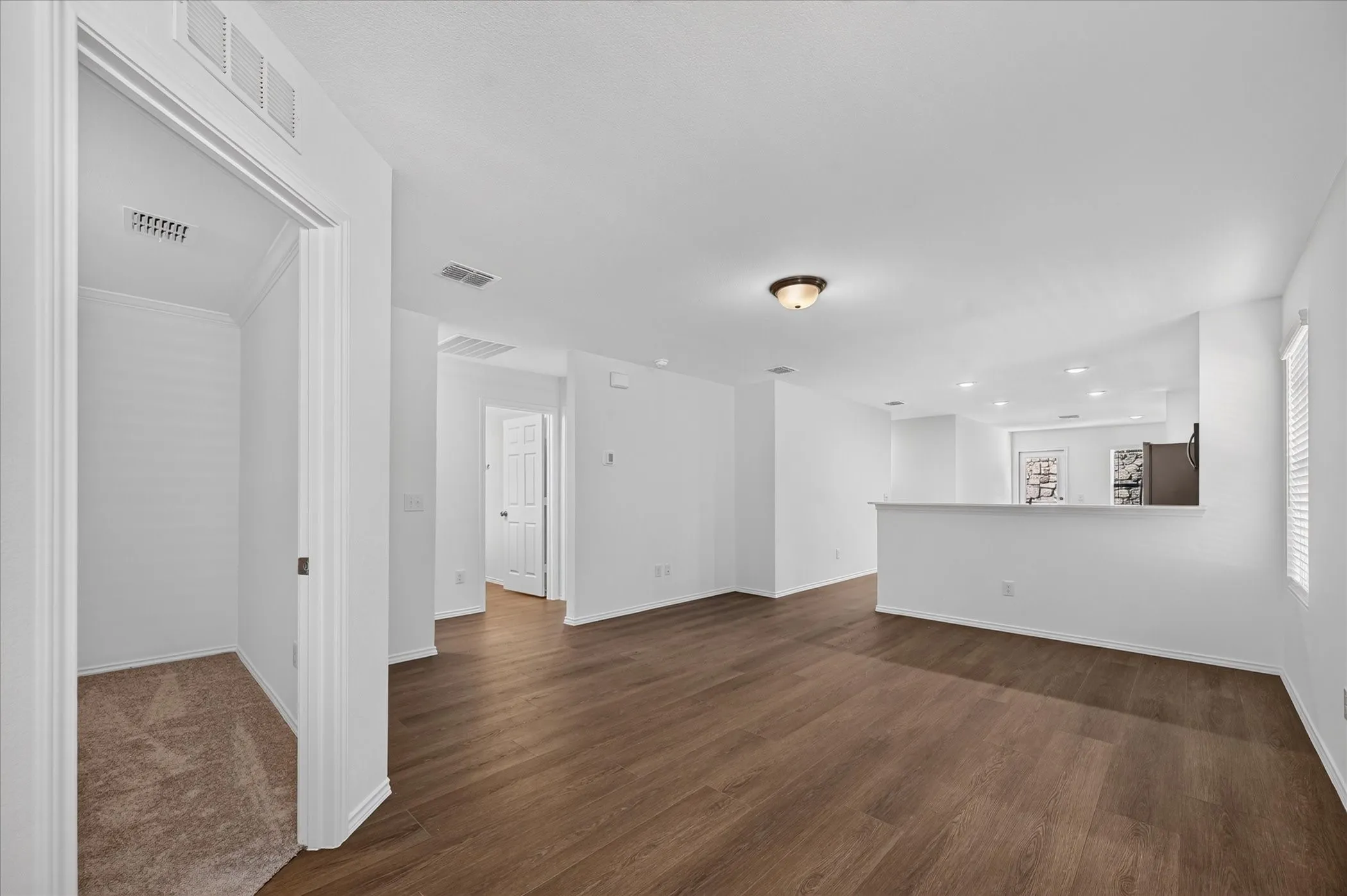 Open-concept living area featuring wood-finish flooring, recessed lighting, and a breakfast bar