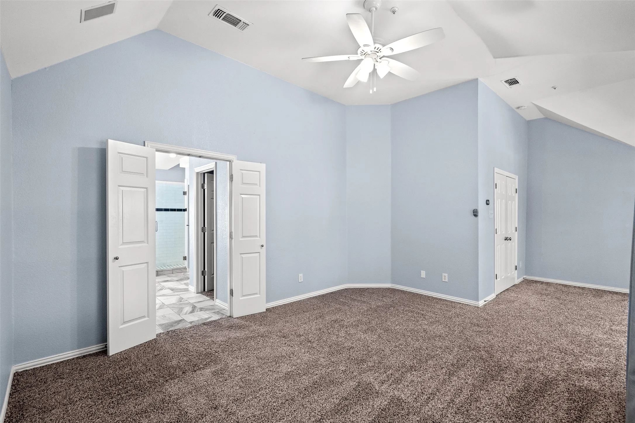 Vaulted ceilings with a ceiling fan, carpeted flooring, and light blue wall finish