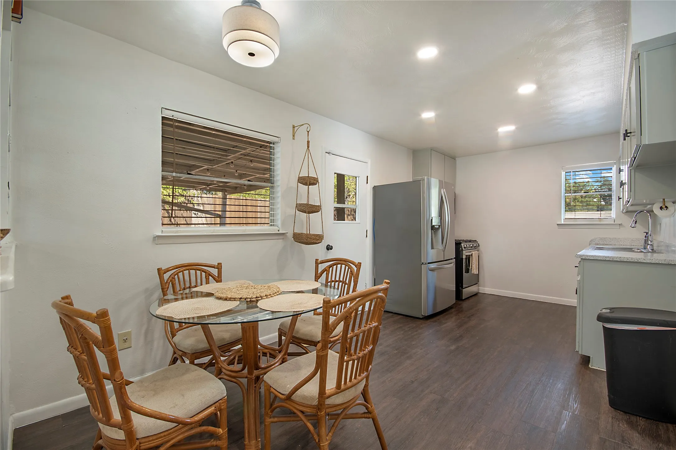 Wood-finish flooring, recessed lighting, and a stainless steel refrigerator