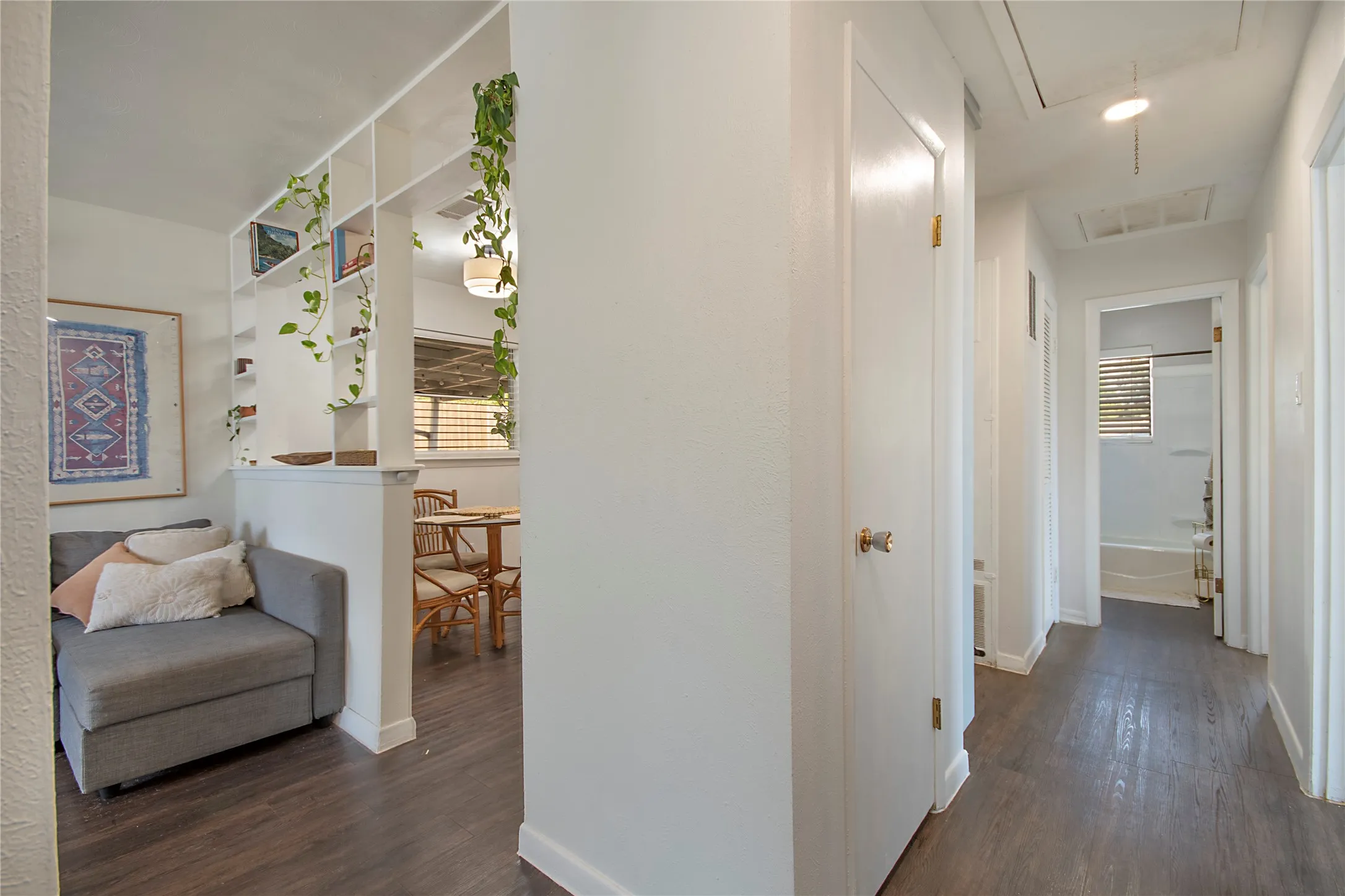 Wood-finish flooring throughout, white walls, and a recessed ceiling light