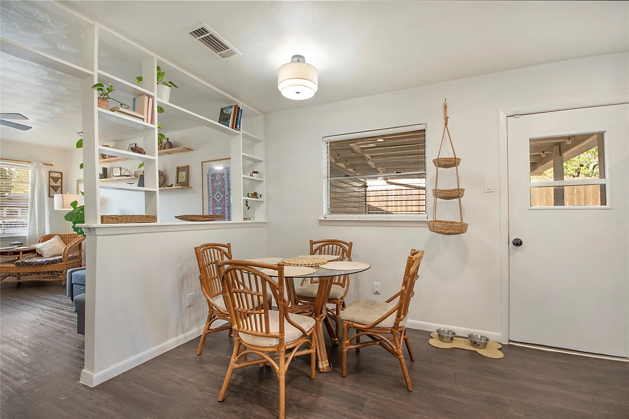 Built-in shelving unit, wood-finish flooring, recessed lighting, and a window with blinds