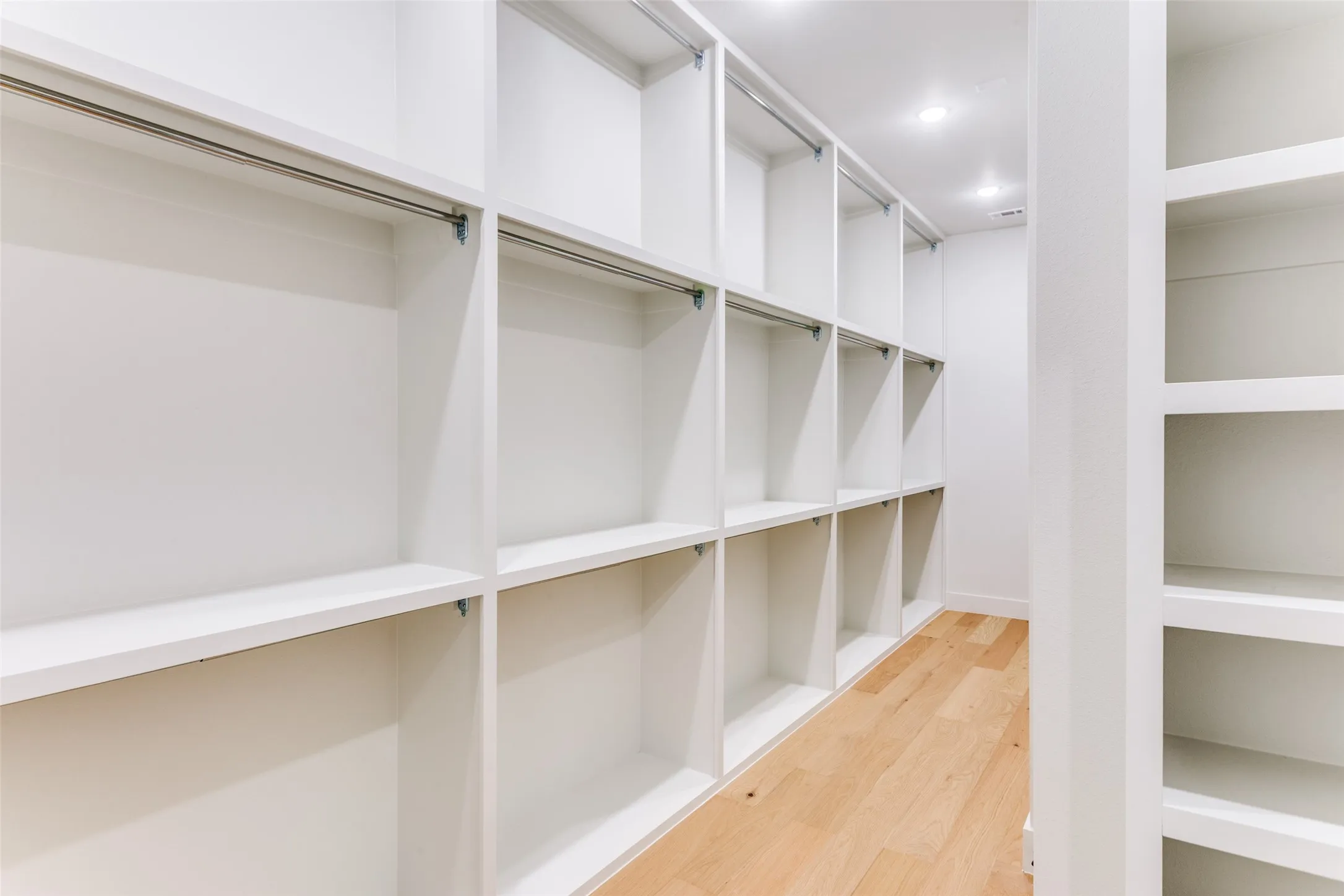 Built-in white shelving with hanging rods