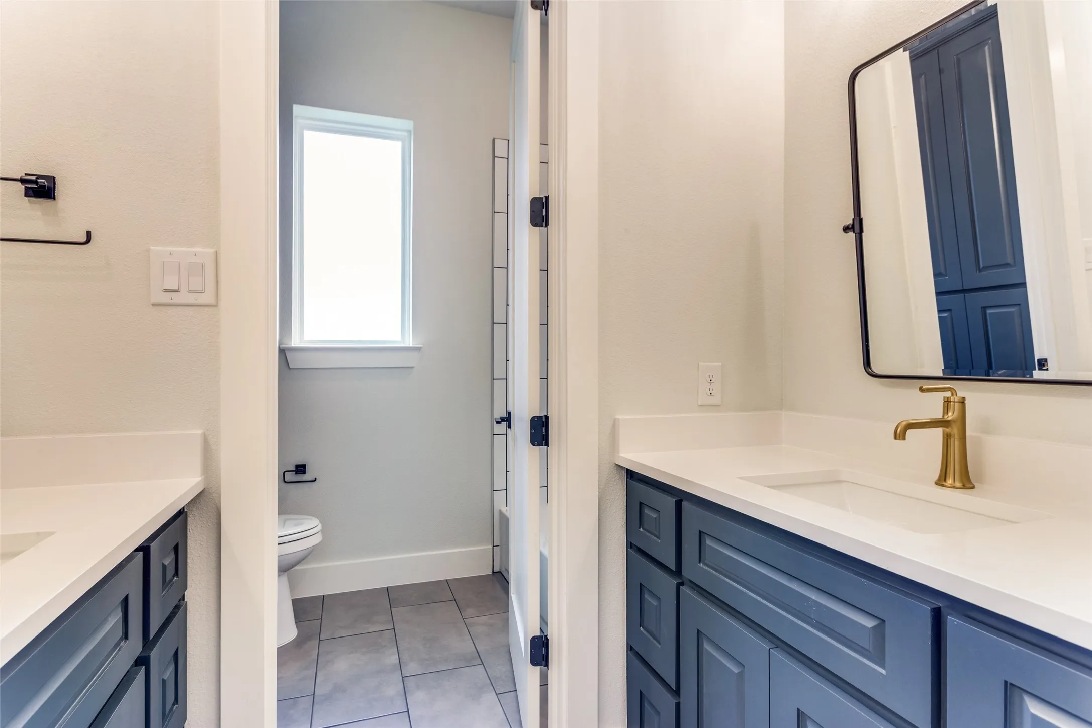 Dual vanity with white countertops and blue cabinetry
