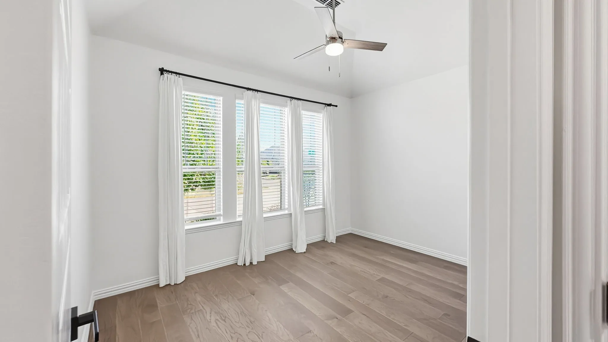 Light wood-finish flooring with white walls and trim