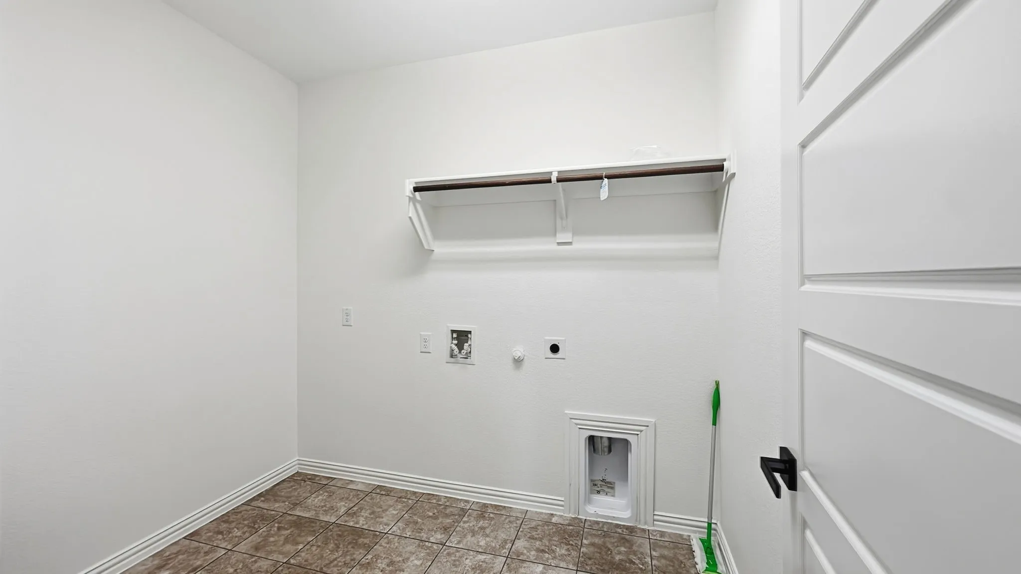 White walls with a single shelf and hanging rod