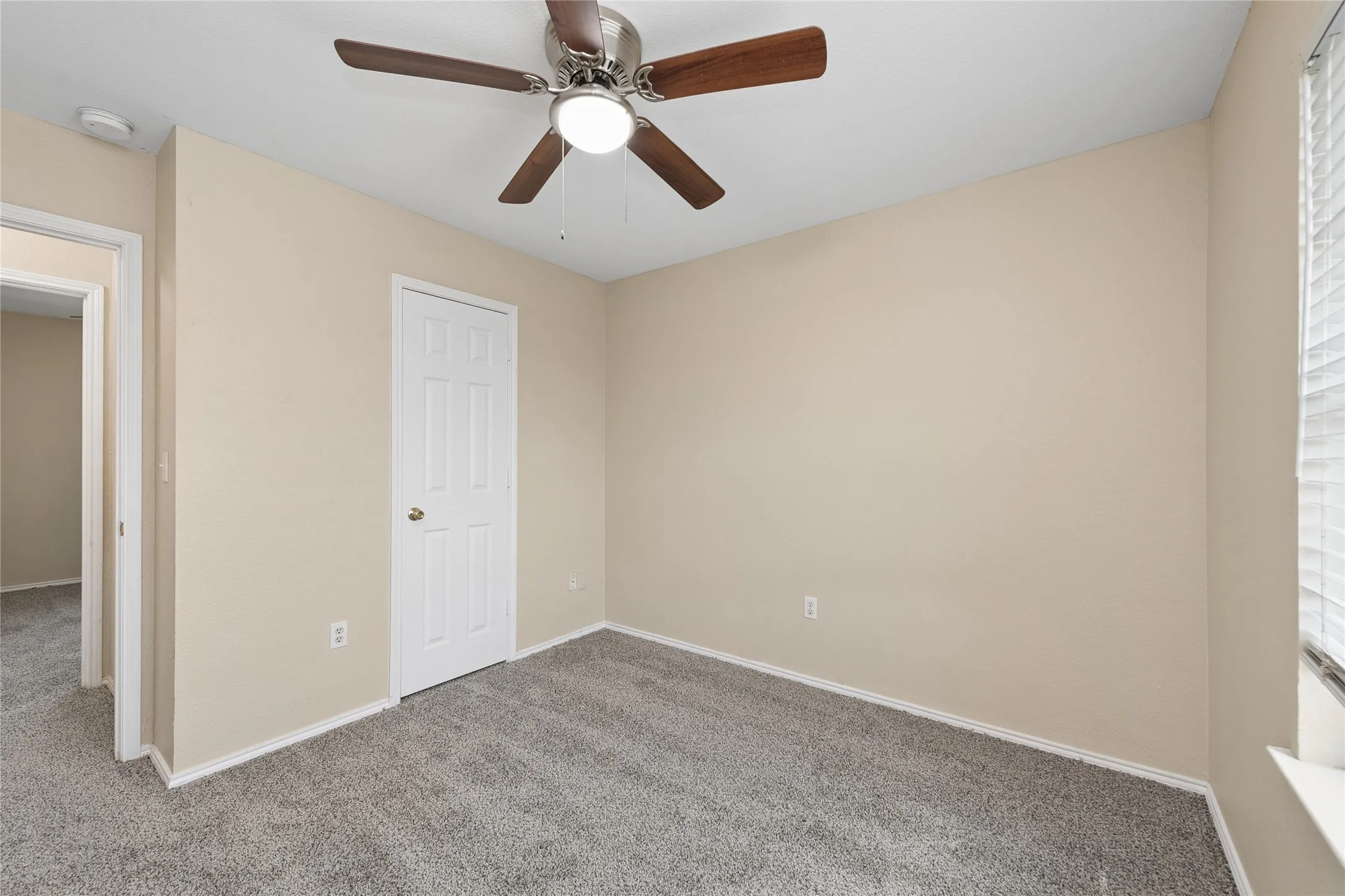 Neutral-toned walls complement plush carpeting