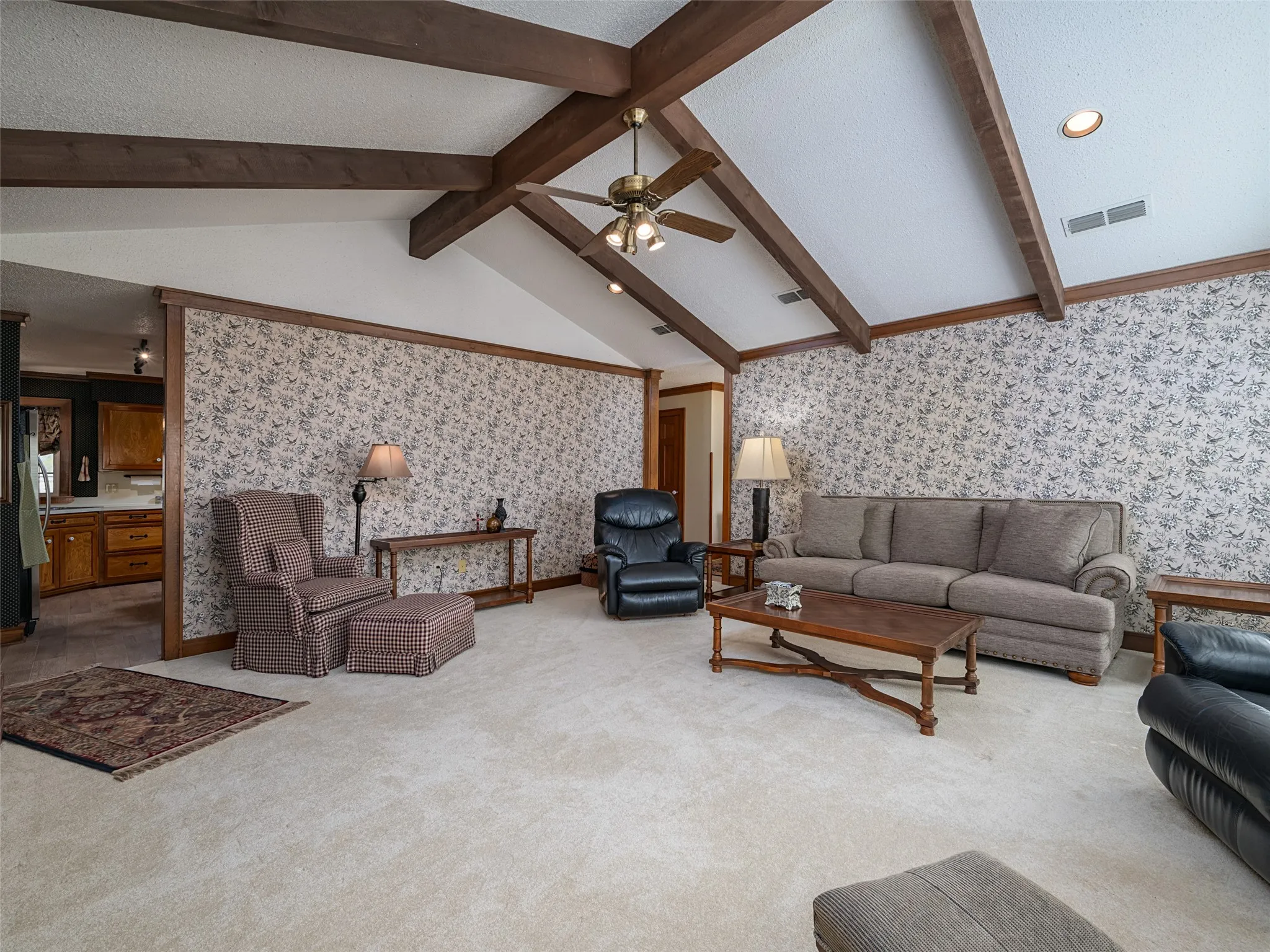Vaulted ceiling with exposed wood beams, recessed lighting, ceiling fan, and carpet flooring