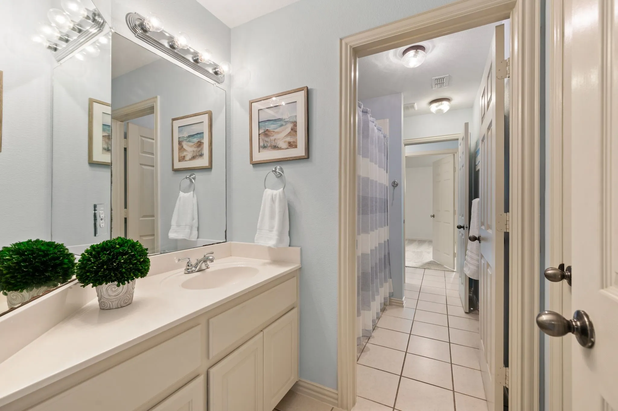 Bathroom vanity with an integrated sink, polished chrome faucet, and expansive mirror