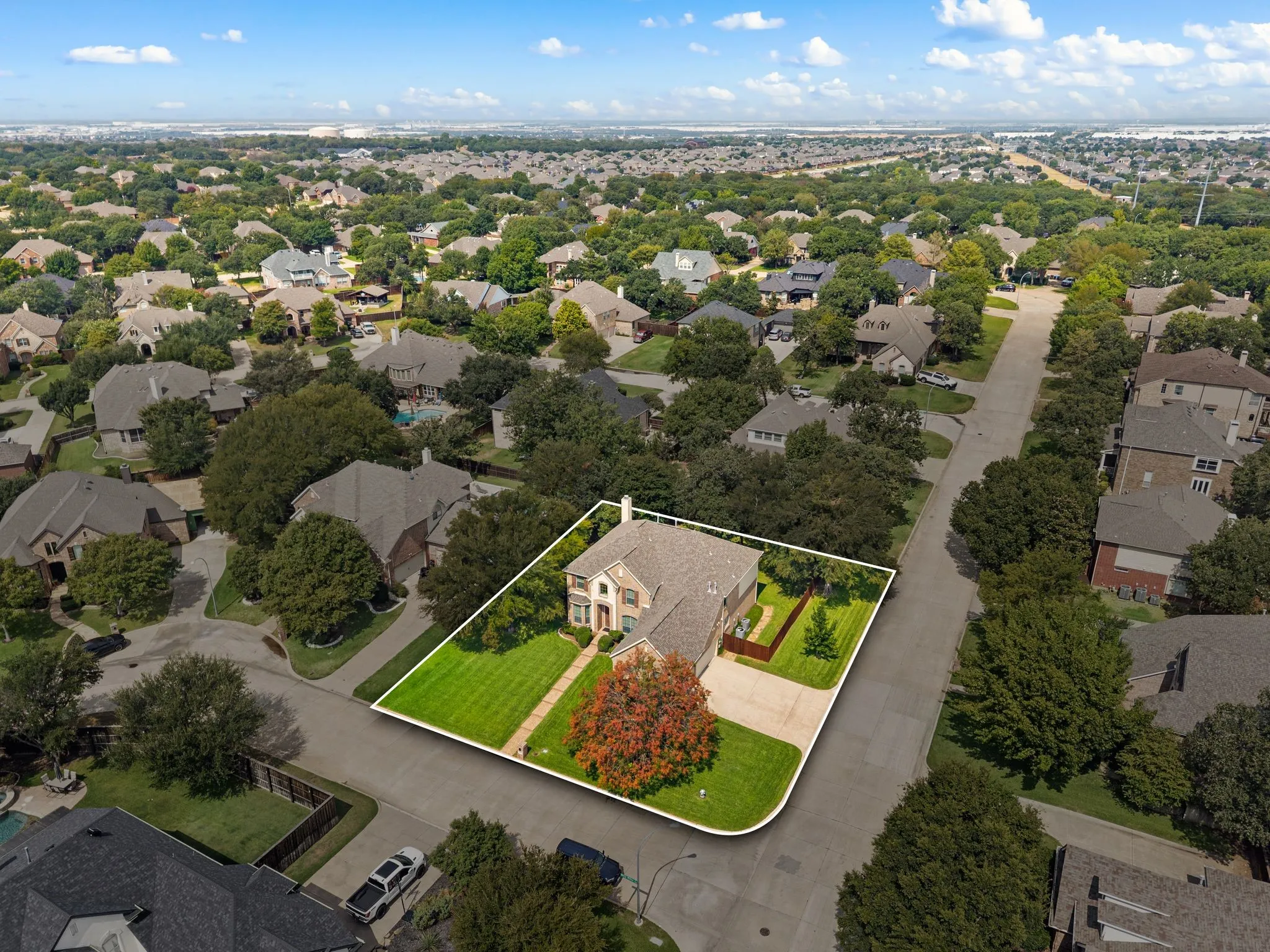 Brick exterior residence with a gabled roof, a paved driveway, and a fenced backyard