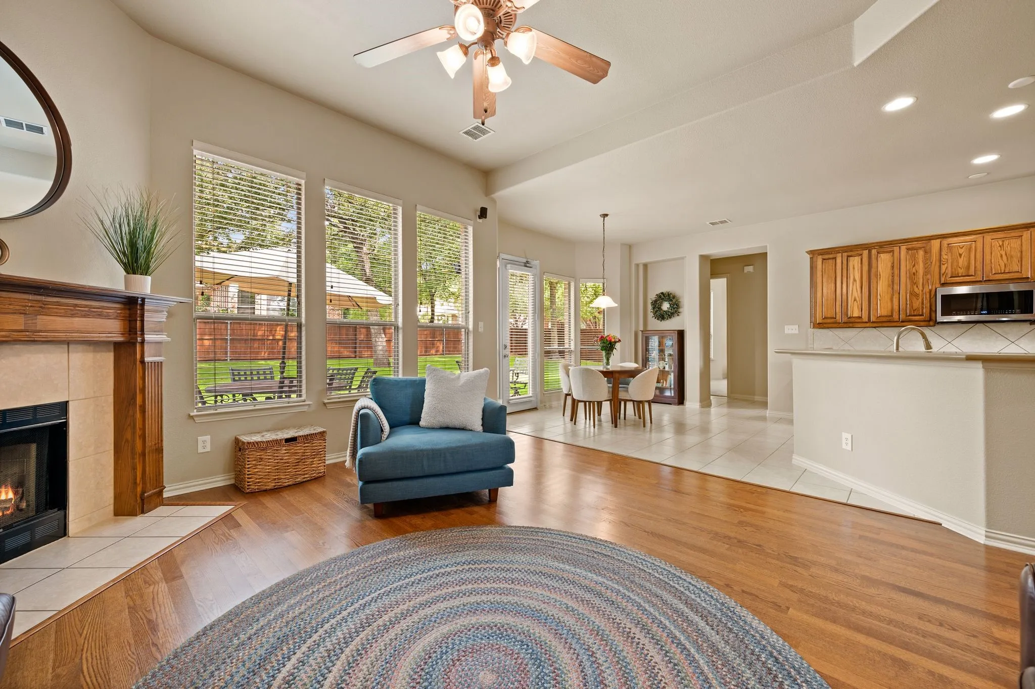 Spacious interior featuring wood-finish flooring, a fireplace with a wood mantel, and multiple windows
