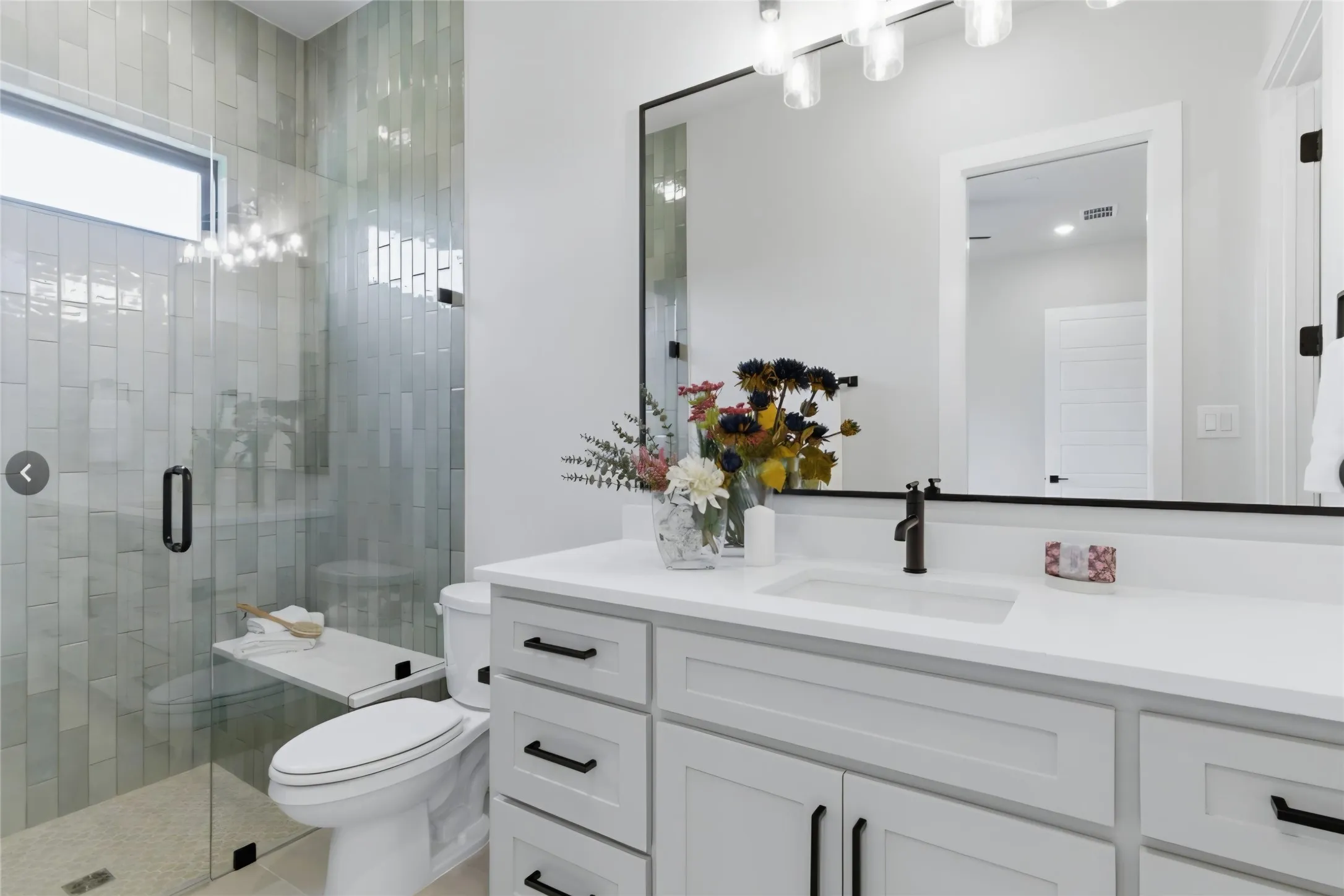White shaker-style cabinetry with matte black hardware, dual undermount sinks, and a white countertop