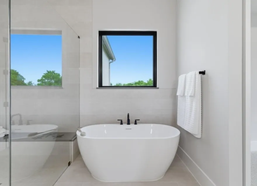 Freestanding soaking tub with a floor-mounted matte black faucet