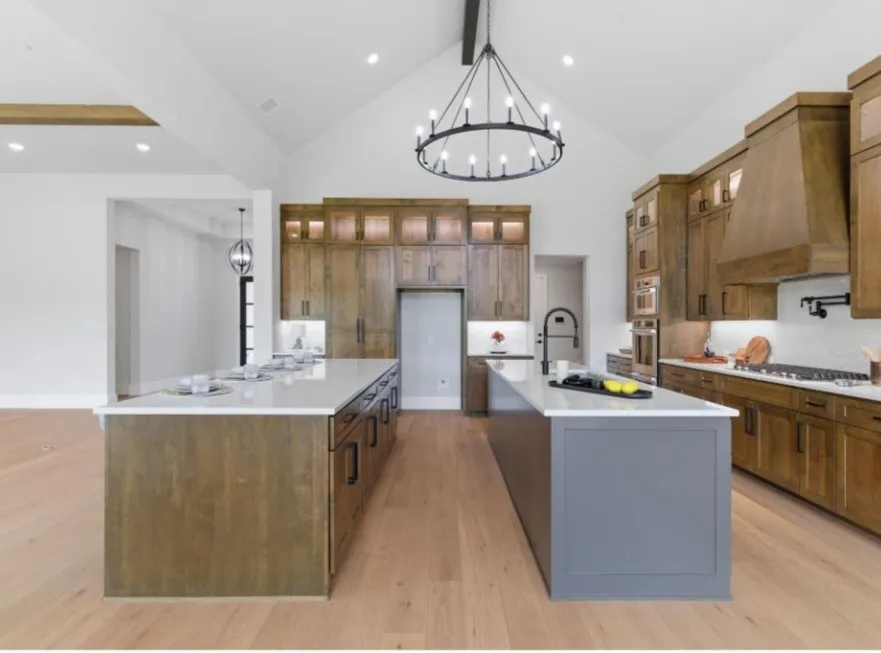 Gourmet kitchen featuring dual islands, natural wood cabinetry, a vaulted ceiling, and recessed lighting