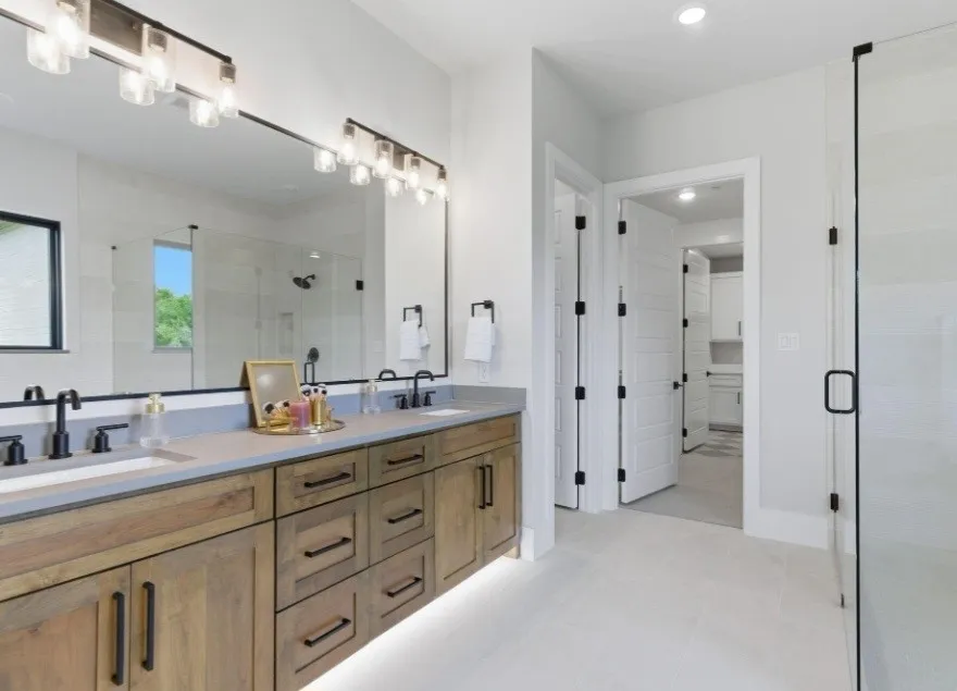Dual vanity with wood-finish cabinetry and undermount lighting