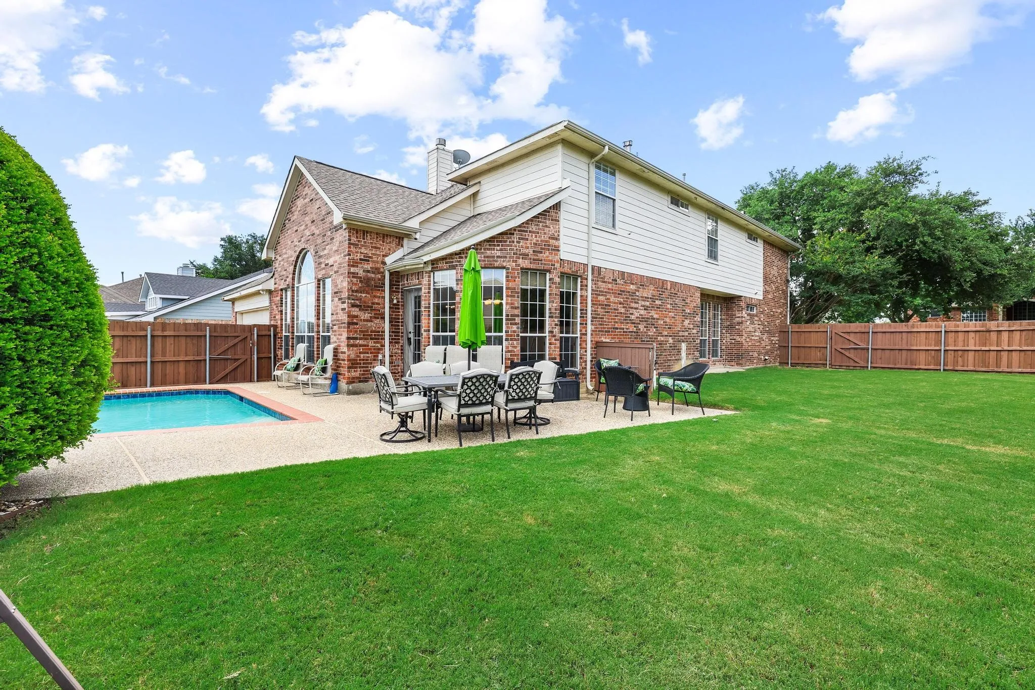 The spacious grassy side yard provides plenty of space in addition to the pool