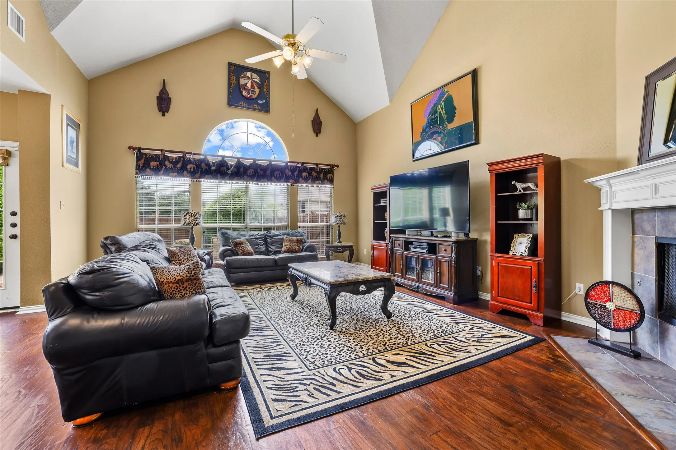 Gas fireplace, wood floors, and large windows overlook the backyard pool