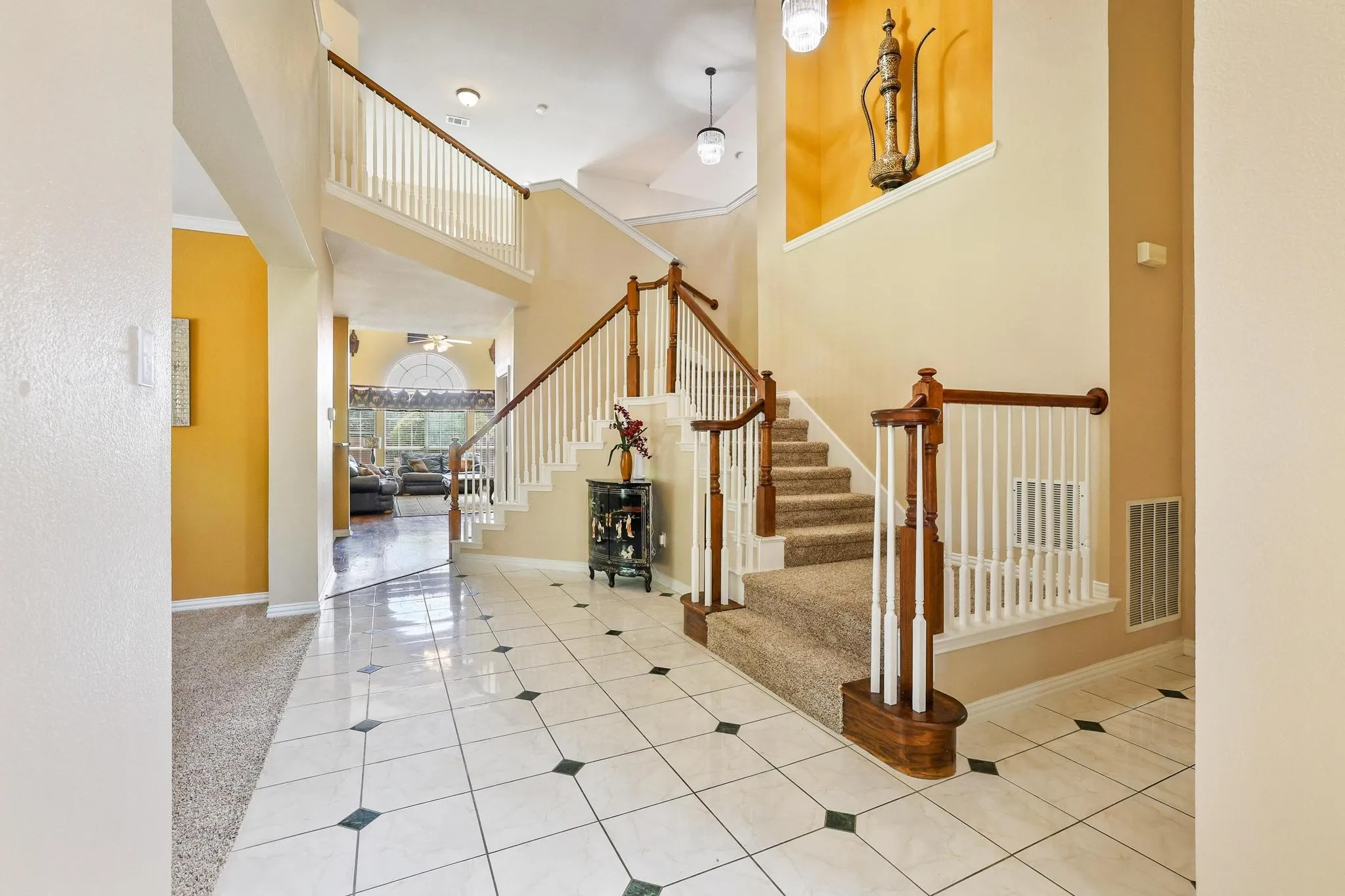 Dual staircase leads to the upstairs bedrooms and game room