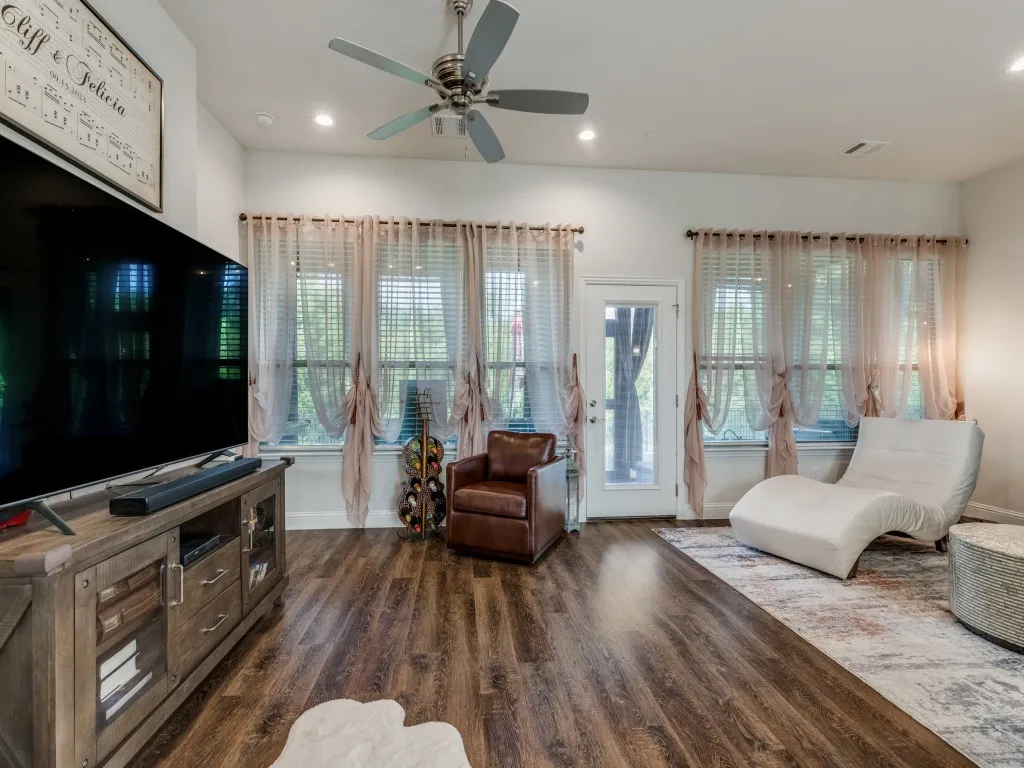 Wood-finish flooring, multiple windows with blinds, recessed lighting, and a ceiling fan