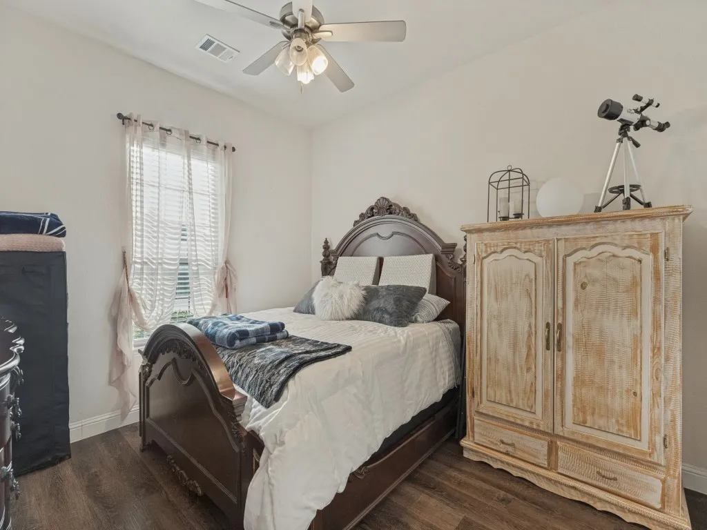 Wood-finish flooring, light-colored walls, window with blinds, and ceiling fan with lighting