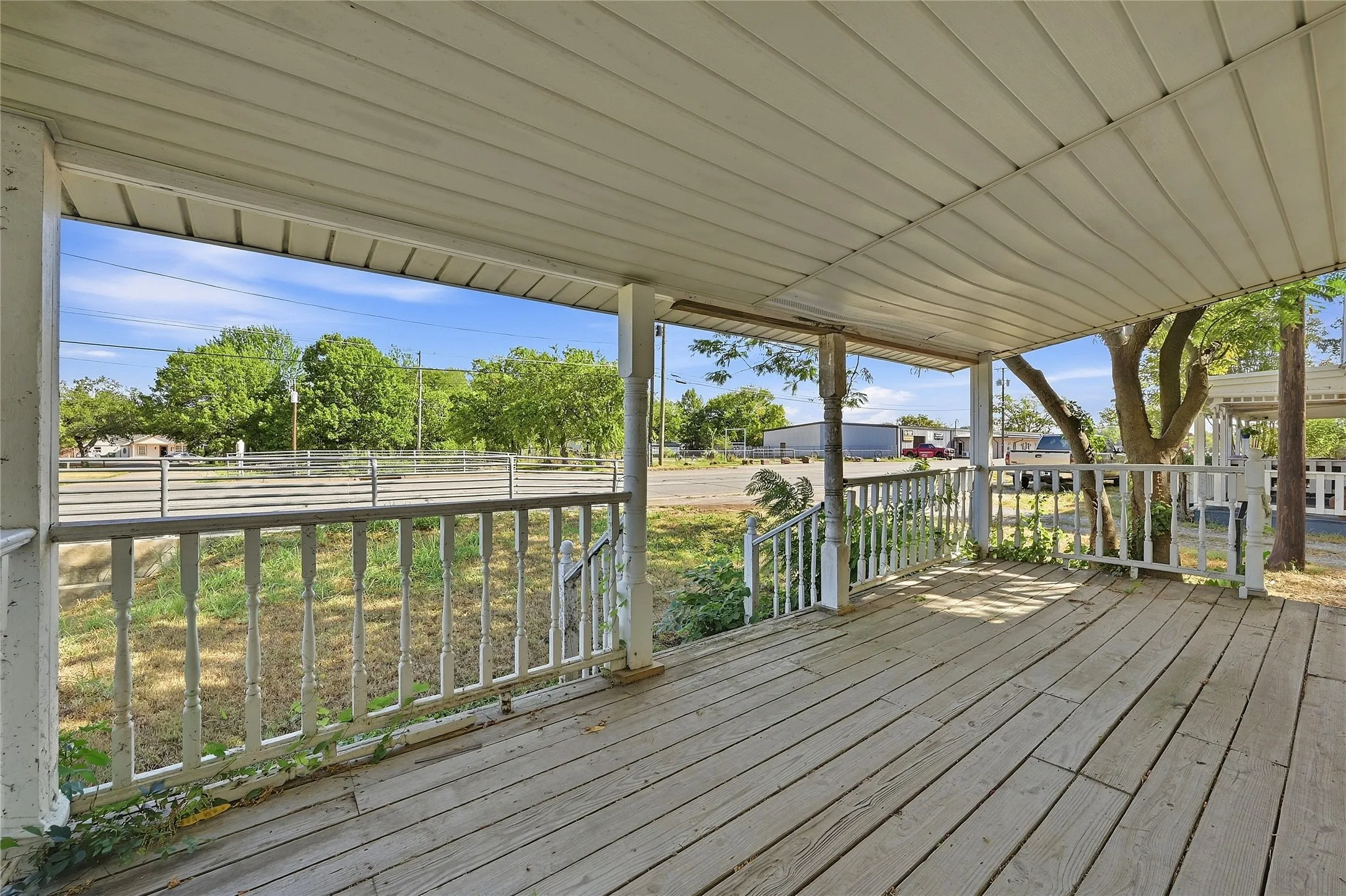 Covered porch with wood flooring and white railing