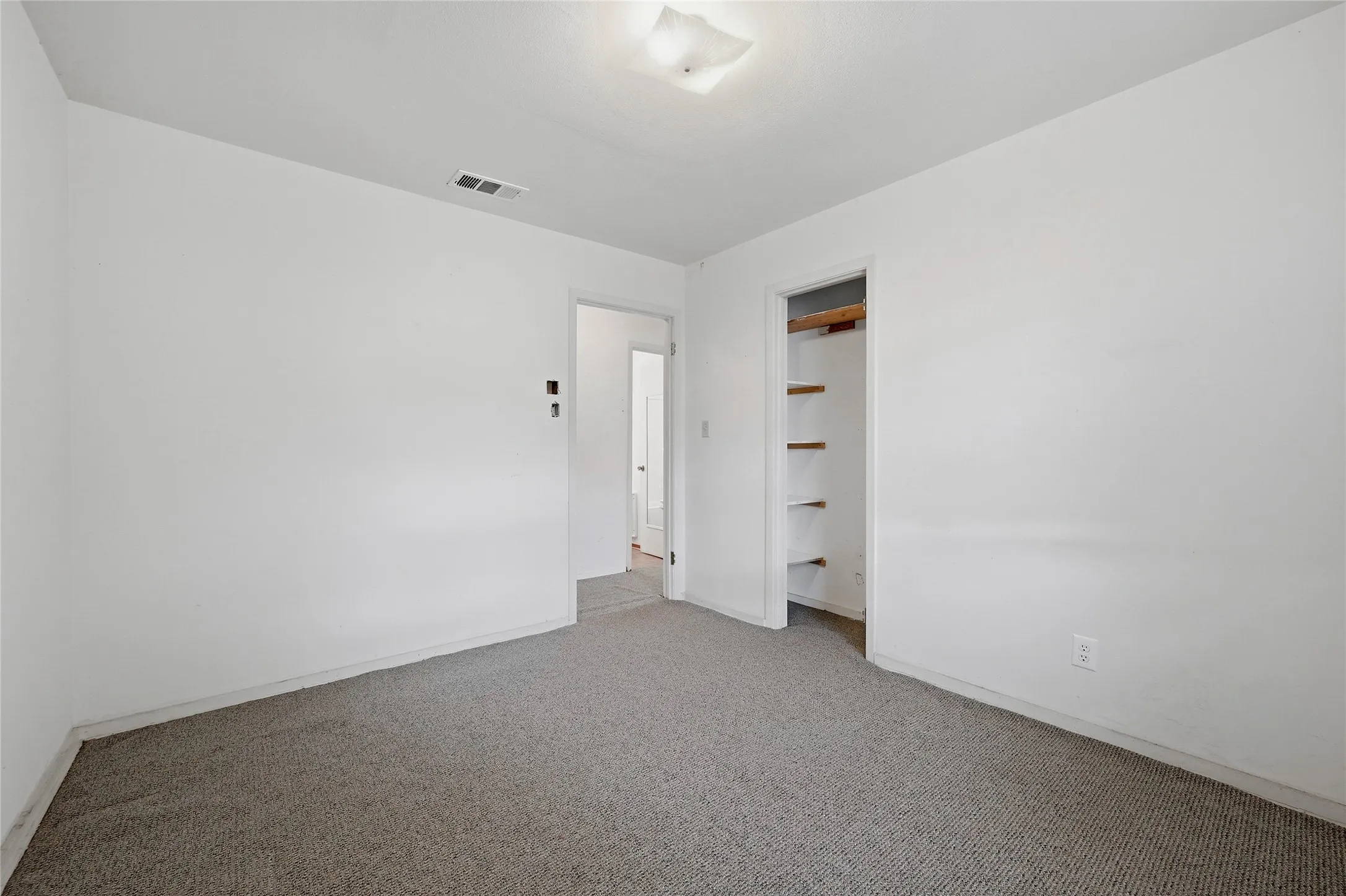 Recessed lighting, wall-to-wall carpeting, and a built-in closet with shelving