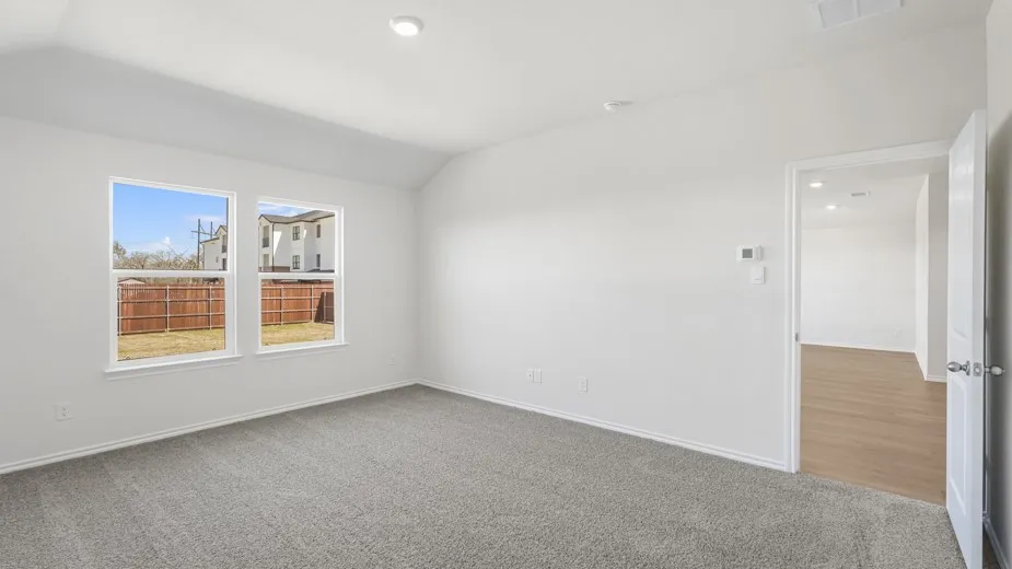 White walls, gray carpeting, a vaulted ceiling, recessed lighting, and dual windows