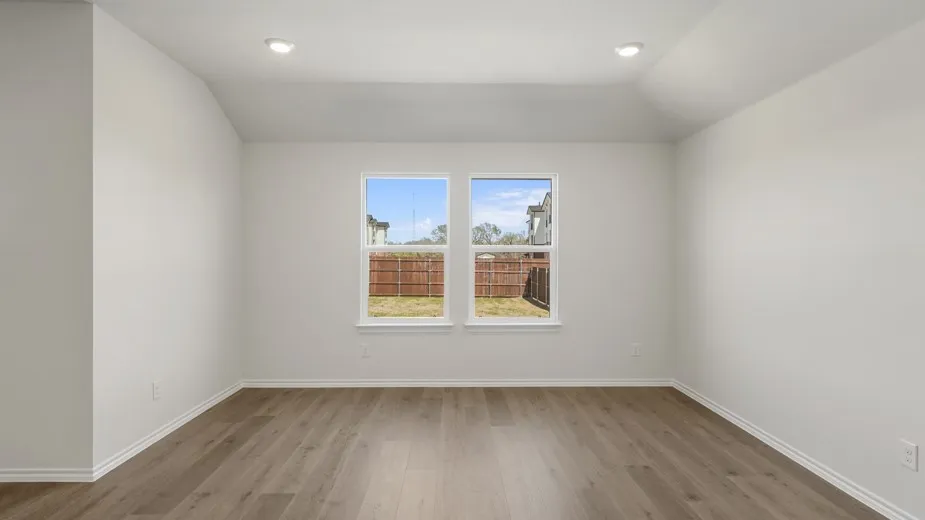 Vaulted ceiling featuring recessed lighting, wood-finish flooring, and white walls