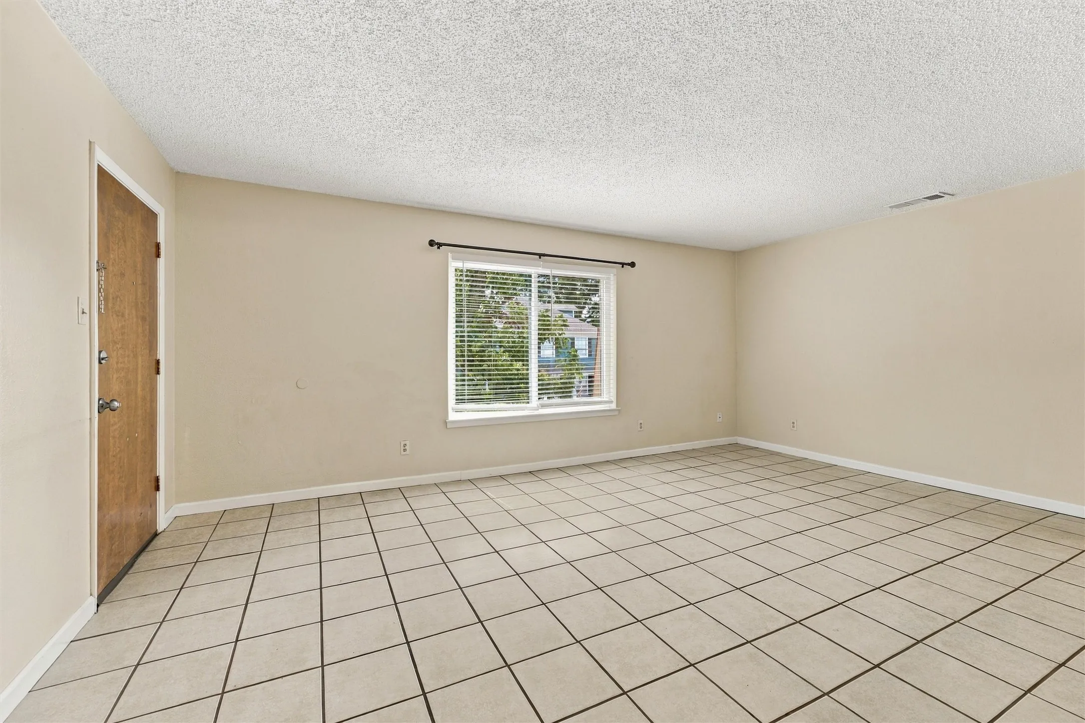 Expansive room featuring neutral wall paint and tile flooring