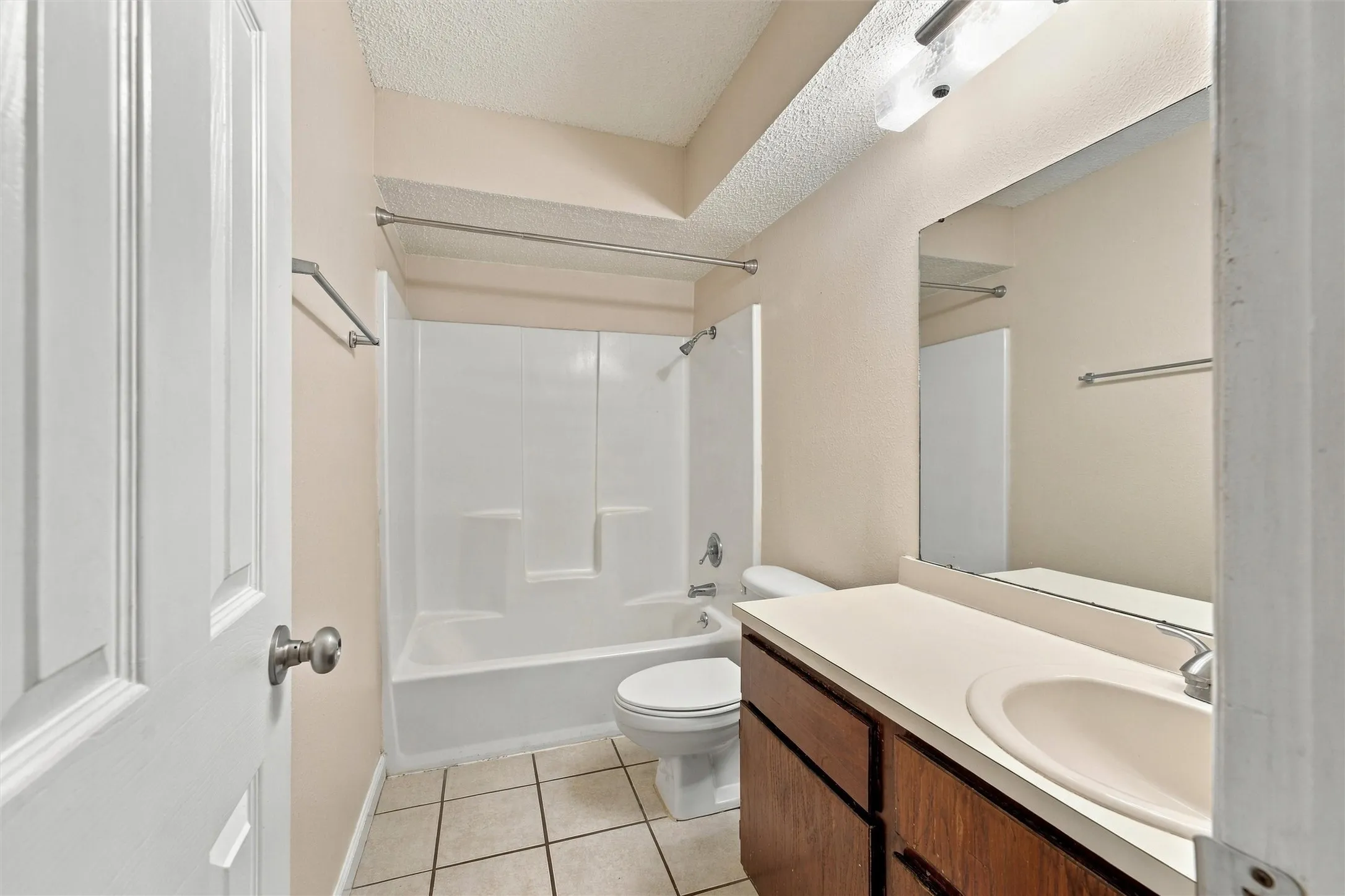 Full bathroom featuring a shower-tub combination, a vanity with a surface-mounted sink, and a large wall-mounted mirror