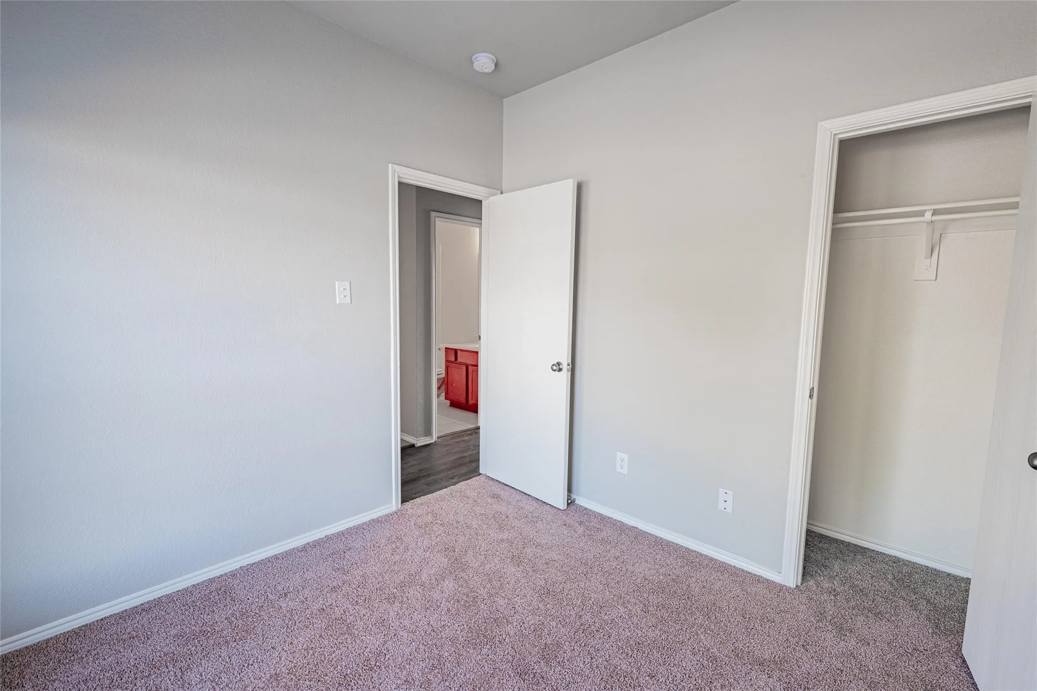Carpet flooring and a built-in closet with shelving